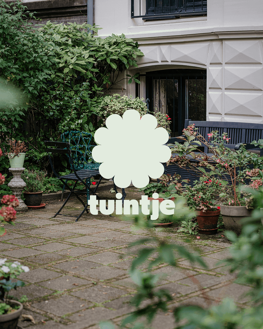 tinygarden tuintje identity applied in a lush garden courtyard setting in Amsterdam, showing the localized logotype in white against green foliage