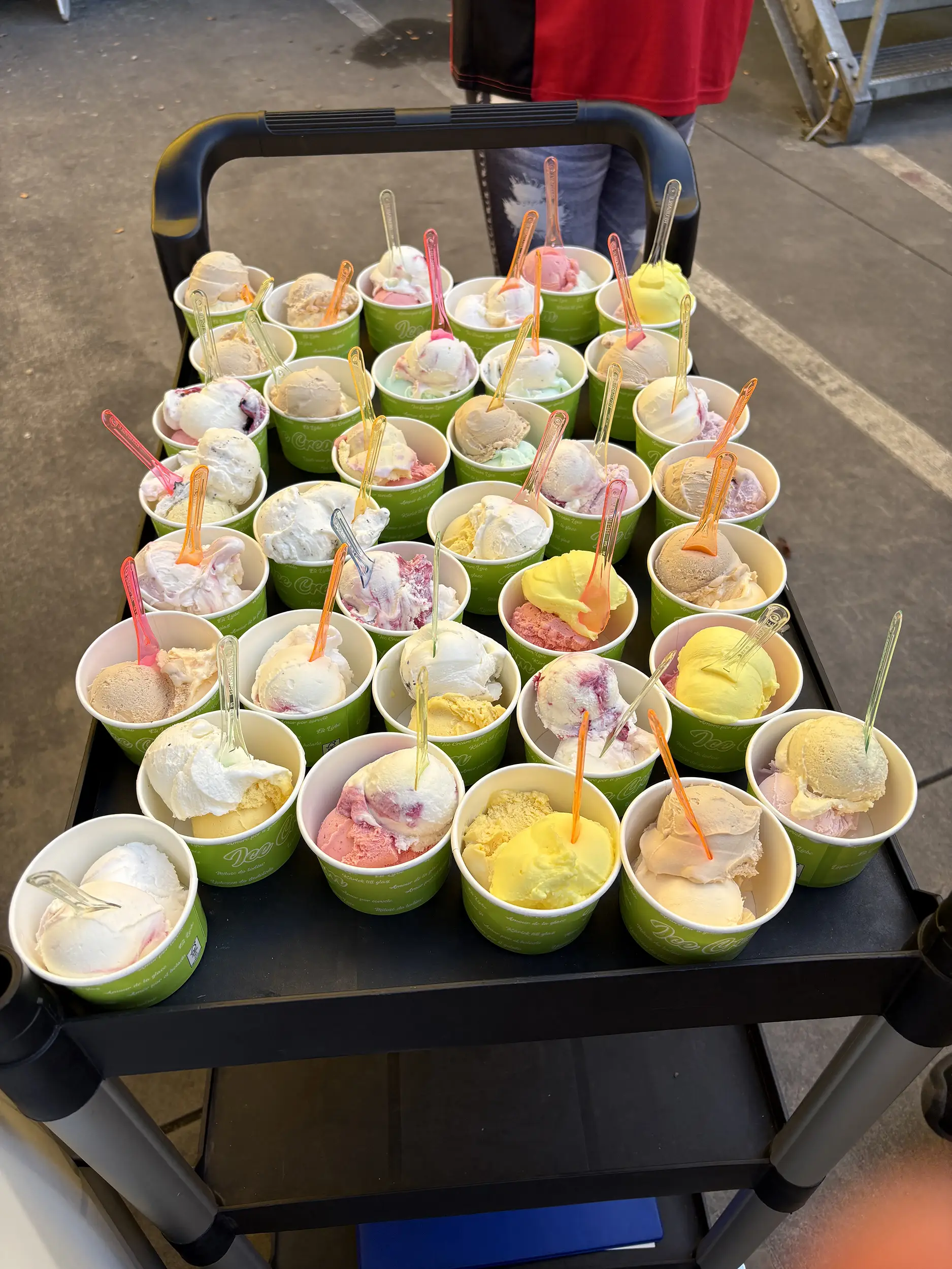 Becher mit verschiedenen handgemachten Eissorten auf einem Servierwagen