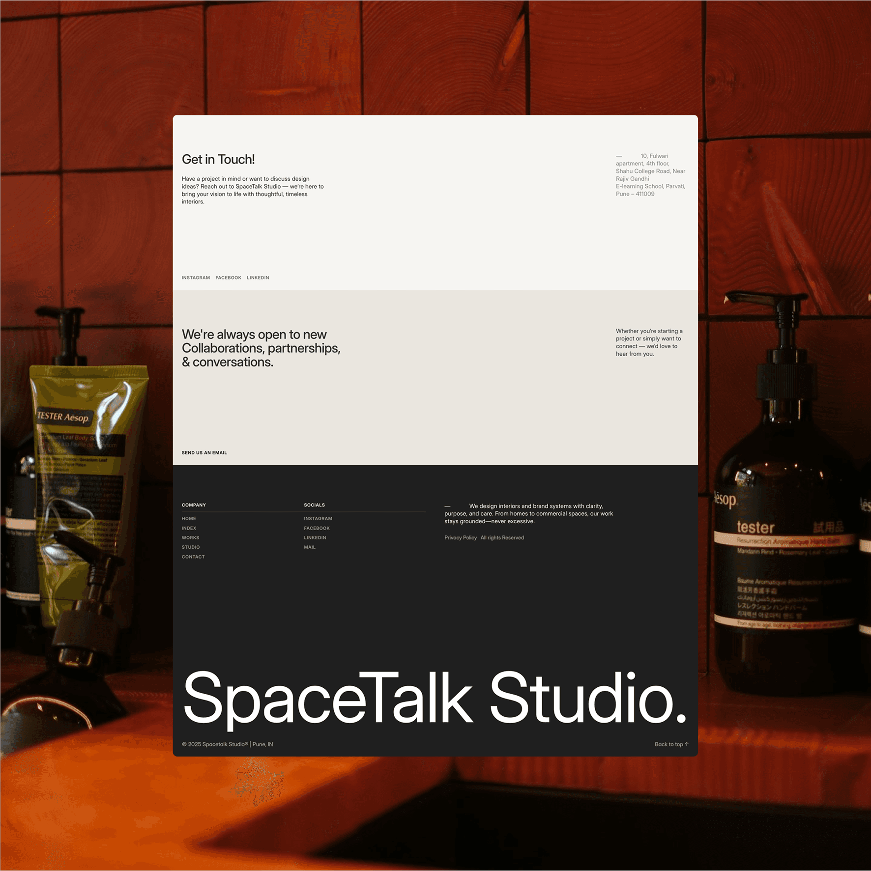 The image showcases a poster for SpaceTalk Studio placed in a stylish bathroom setting, featuring contact information and brand details against a background with skincare products and wooden textures.