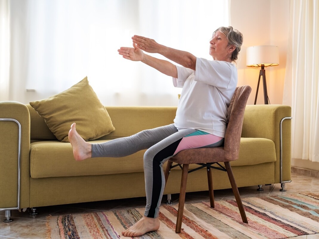 older woman doing gentle seated exercises for seniors to lose weight that are easy for beginners