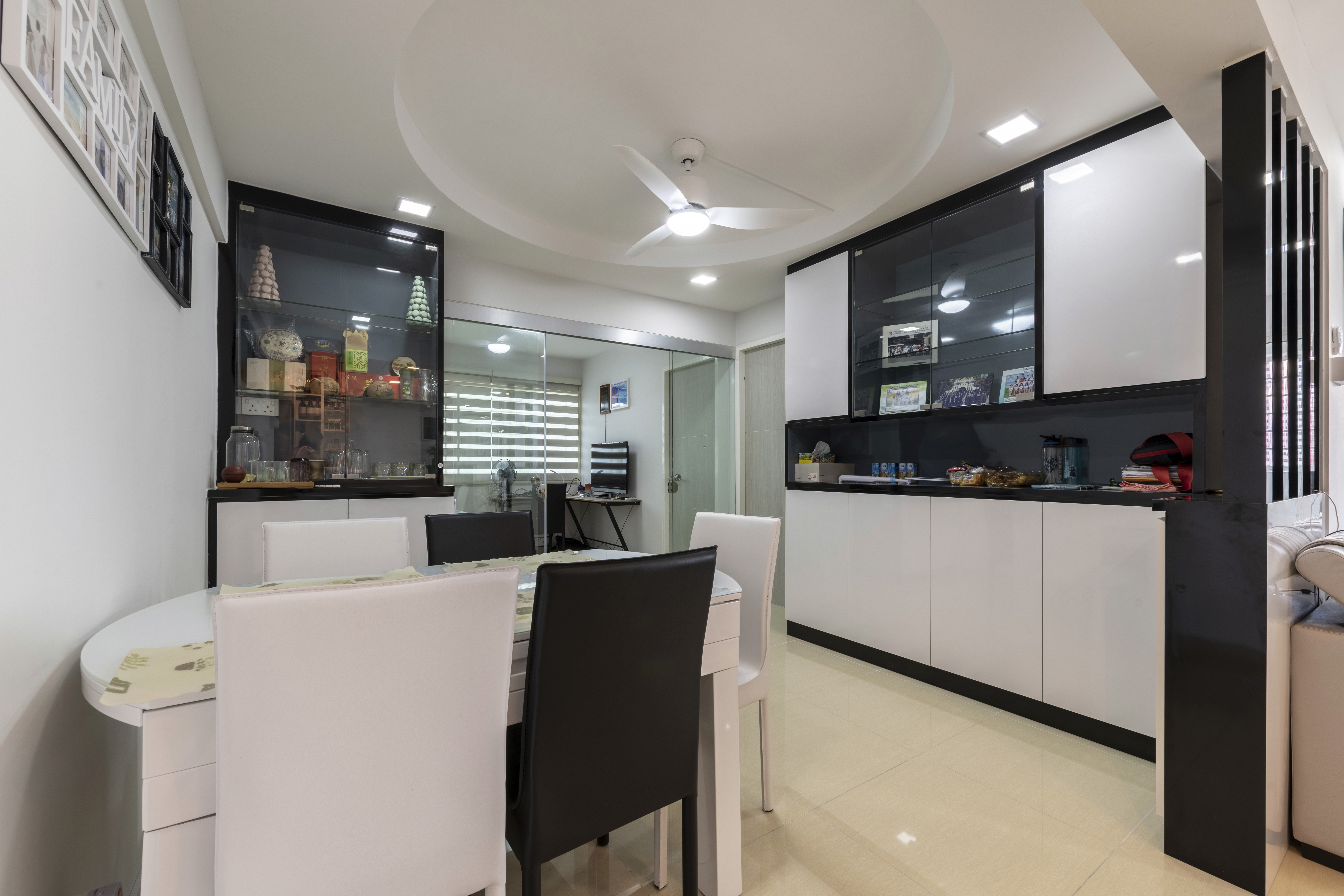 Dining area highlighted by a circular ceiling detail and fluted cabinetry, combining practical storage with an elegant design statement.