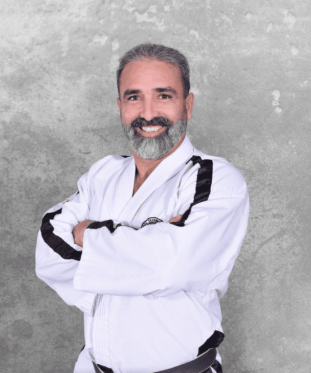 Mr Millan posing arms crossed in his Martial Arts Uniform