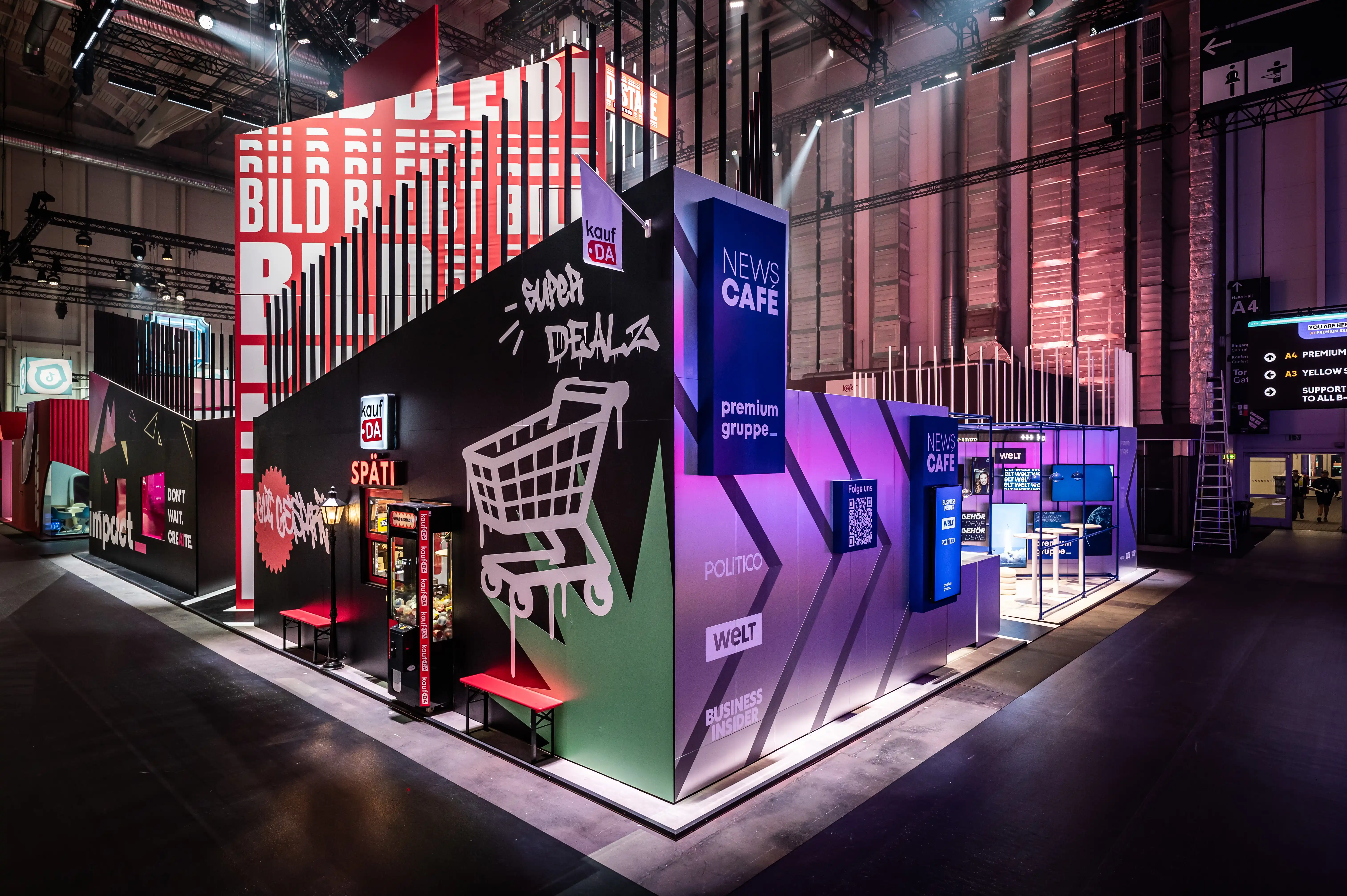 Booth corner with graffiti-style Späti graphics and News Café tower of the premium group brands.