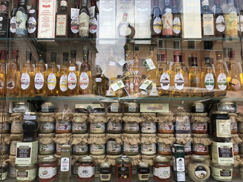 A photo of a window shop filled with different glass bottles and jars.