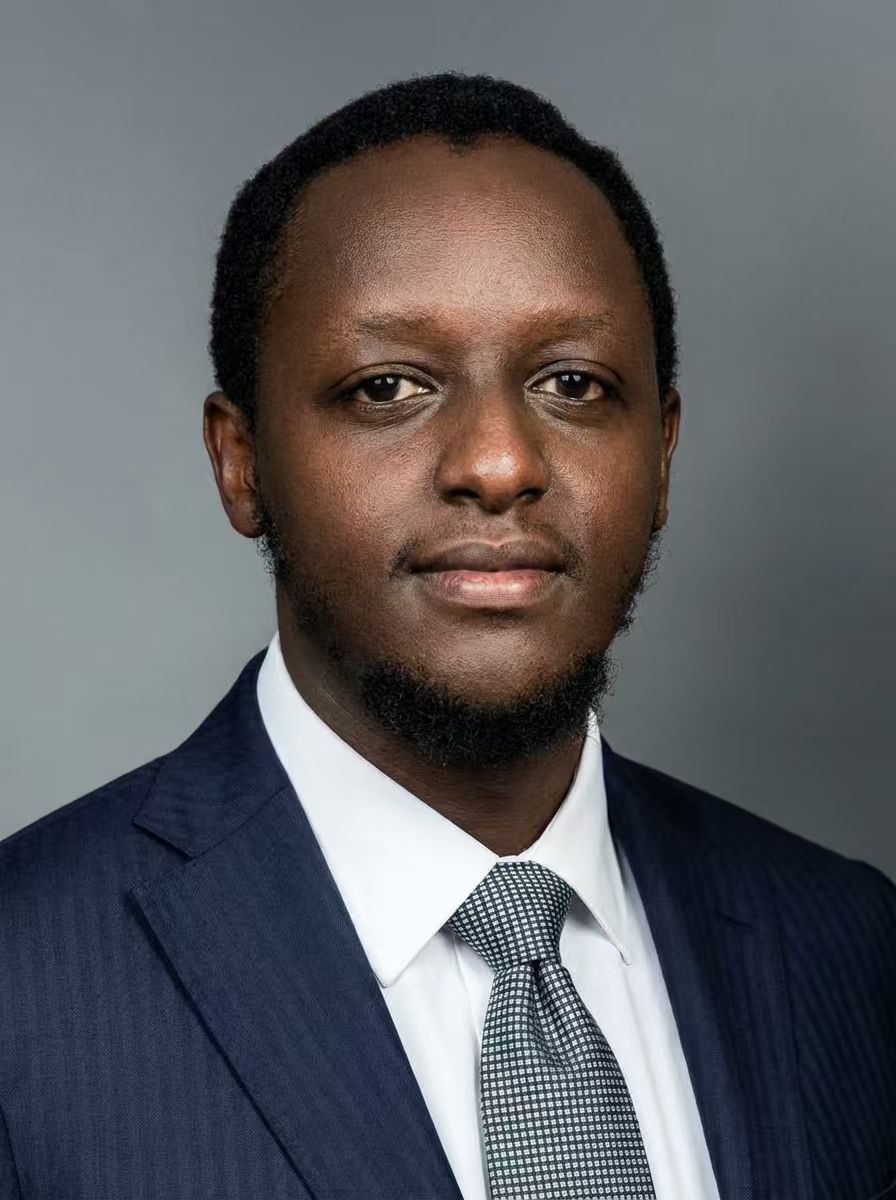 Young woman in a white shirt with a colorful gradient print, against a plain background.