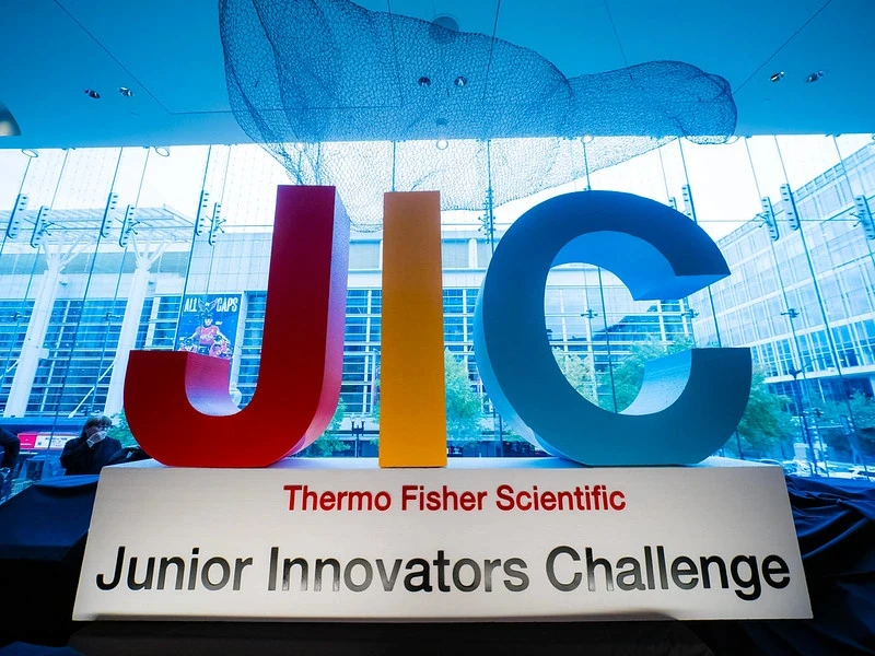 woman in a lab holds up samples. She's doing science research in high school