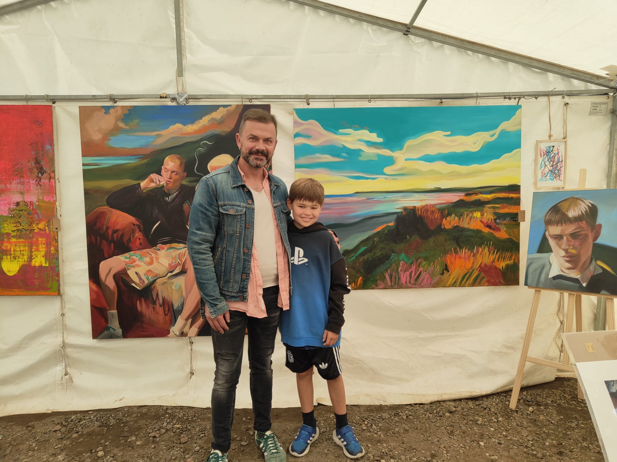 Hrvoje Majer with a young visitor in front of his paintings at Pittenweem Arts Festival, Scotland, 2026