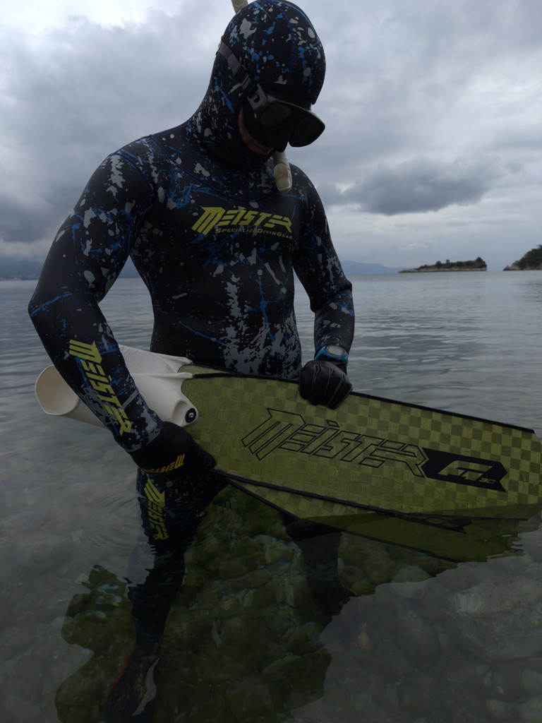 freediver meister sitting on a rock underwater