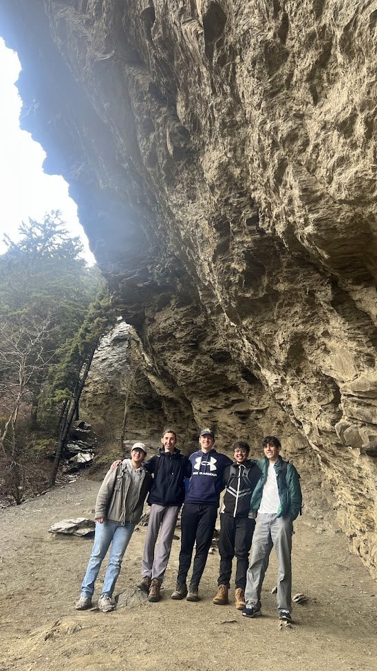 Silver "STUDIO" sign on a brown wooden slatted wall.