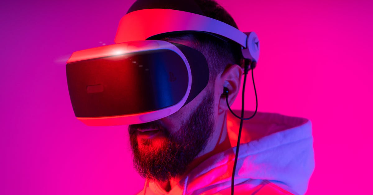A man wearing a VR headset is immersed in virtual reality, illuminated by vibrant pink lighting.