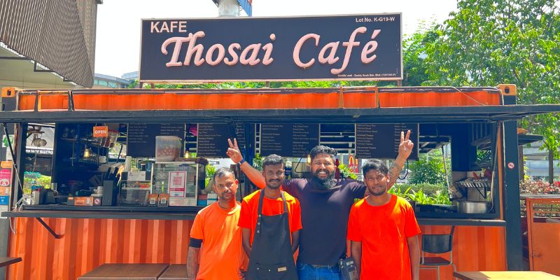 Mithun and his staff smiling in front of Thosai Cafe's container store.