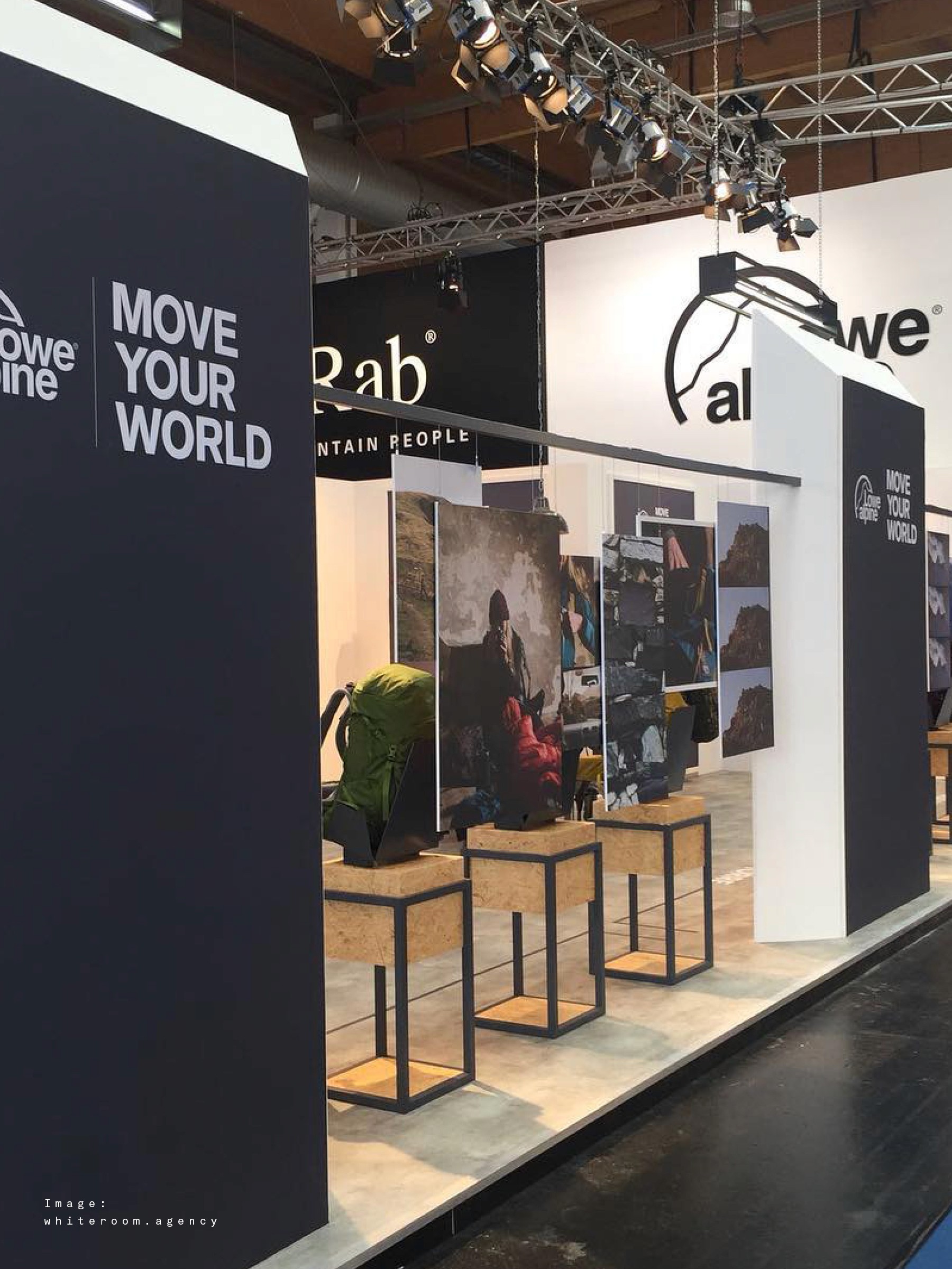 Modern home office setup with a monitor, ergonomic chair, keyboard, and indoor plants near a window with blinds.