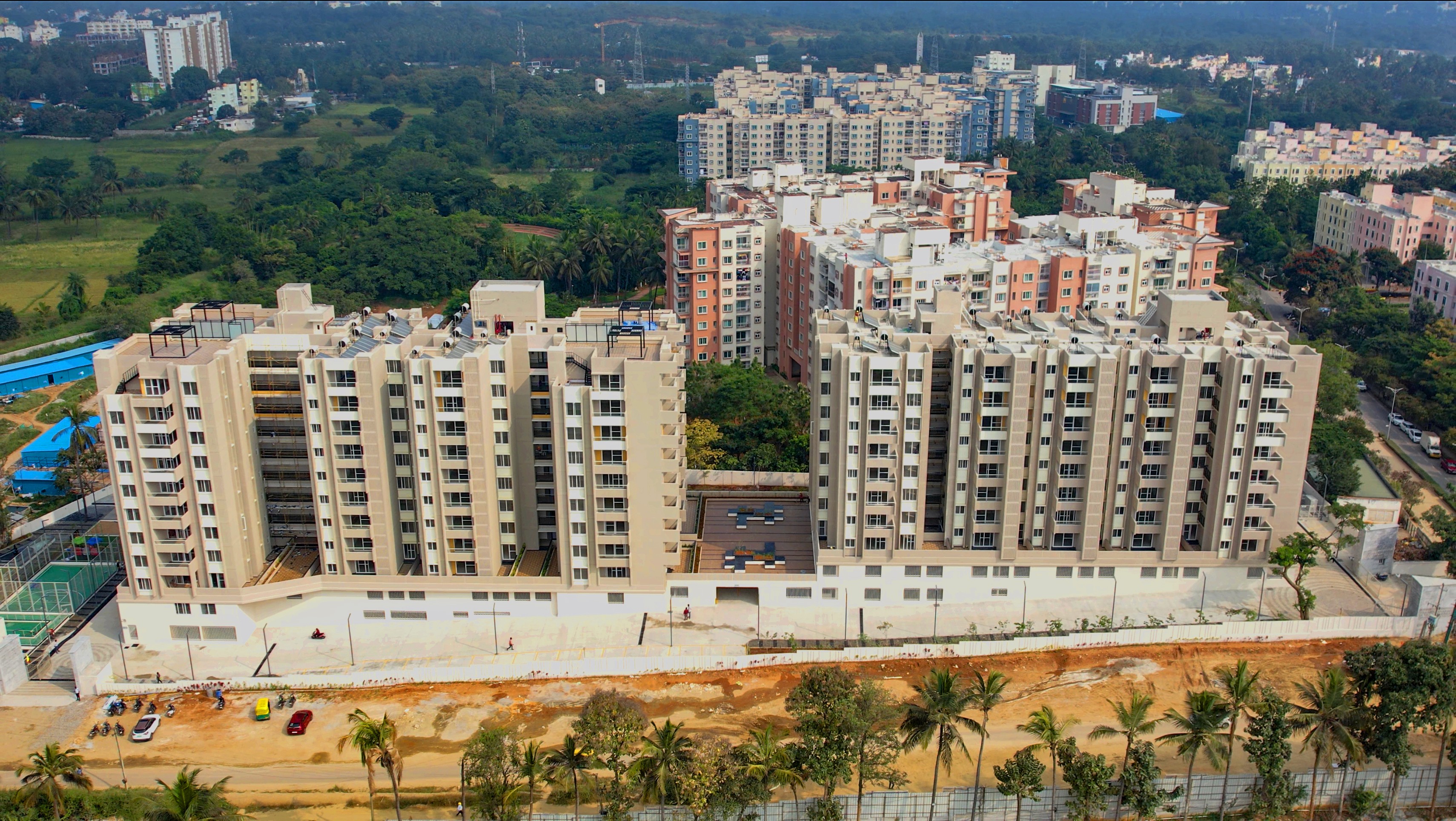 Aerial view of a winding road cutting through rocky terrain and sandy landscape.