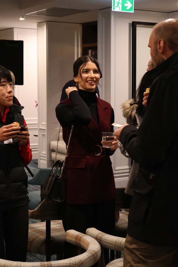 a woman holds a glass and smiles