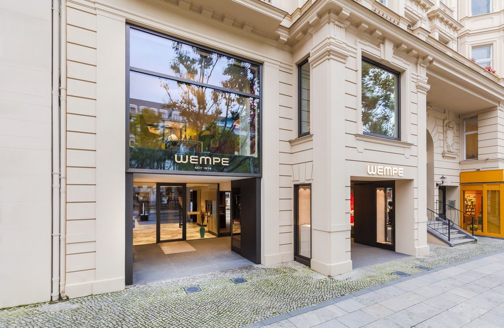 Exterior view of Wempe store with glass doors and large windows showcasing merchandise.