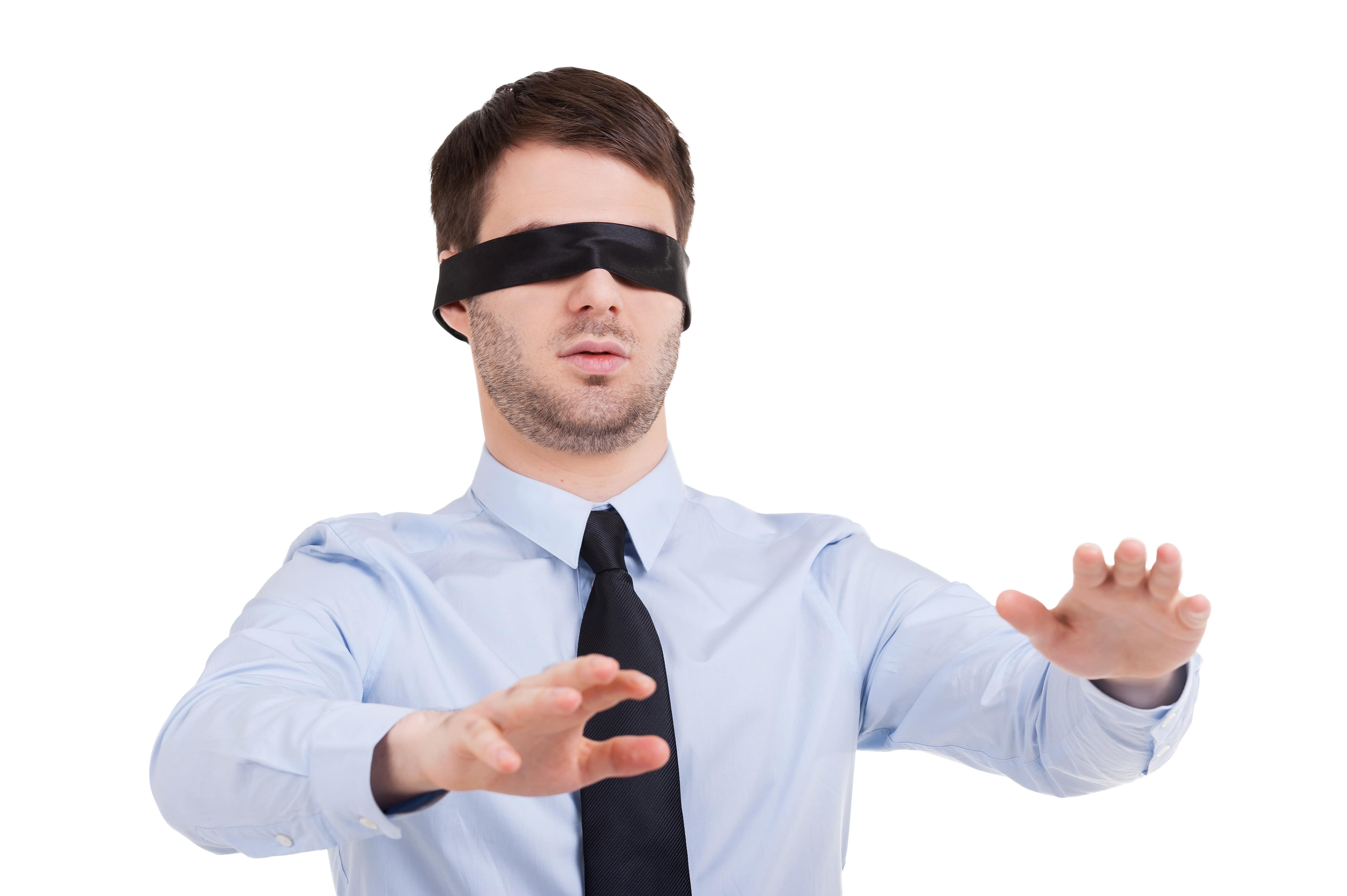 Young formally dressed male with blindfold with hands slightly streched out.