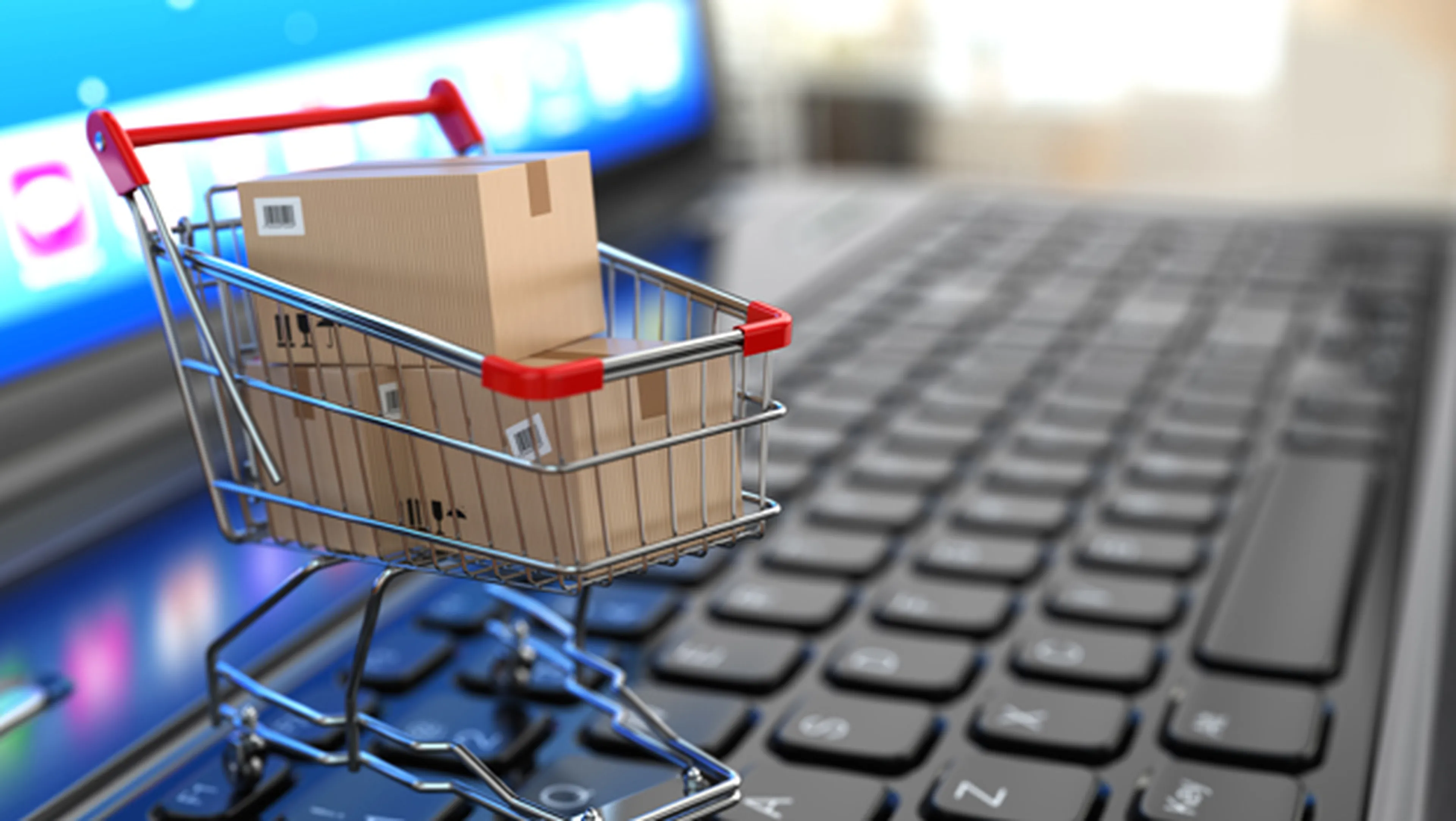 Small Shopping Cart filled with Boxes on Laptop Keyboard