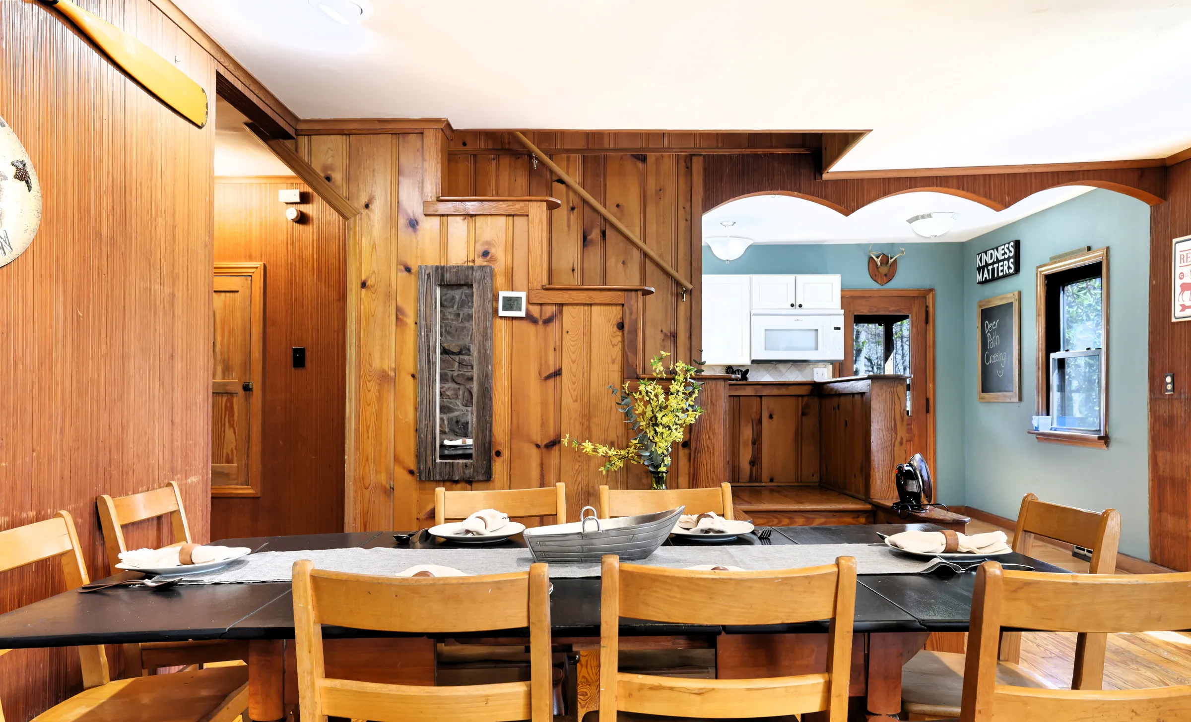 Dining table for ten with wood chairs and kitchen pass-through at DeerPath Crossing