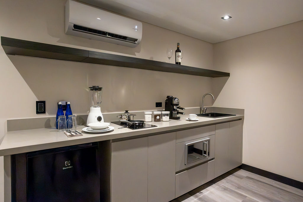 Habitación de lujo con cama king Medellín en Altus Hotel, con ventanales insonorizados y diseño elegante en Laureles.