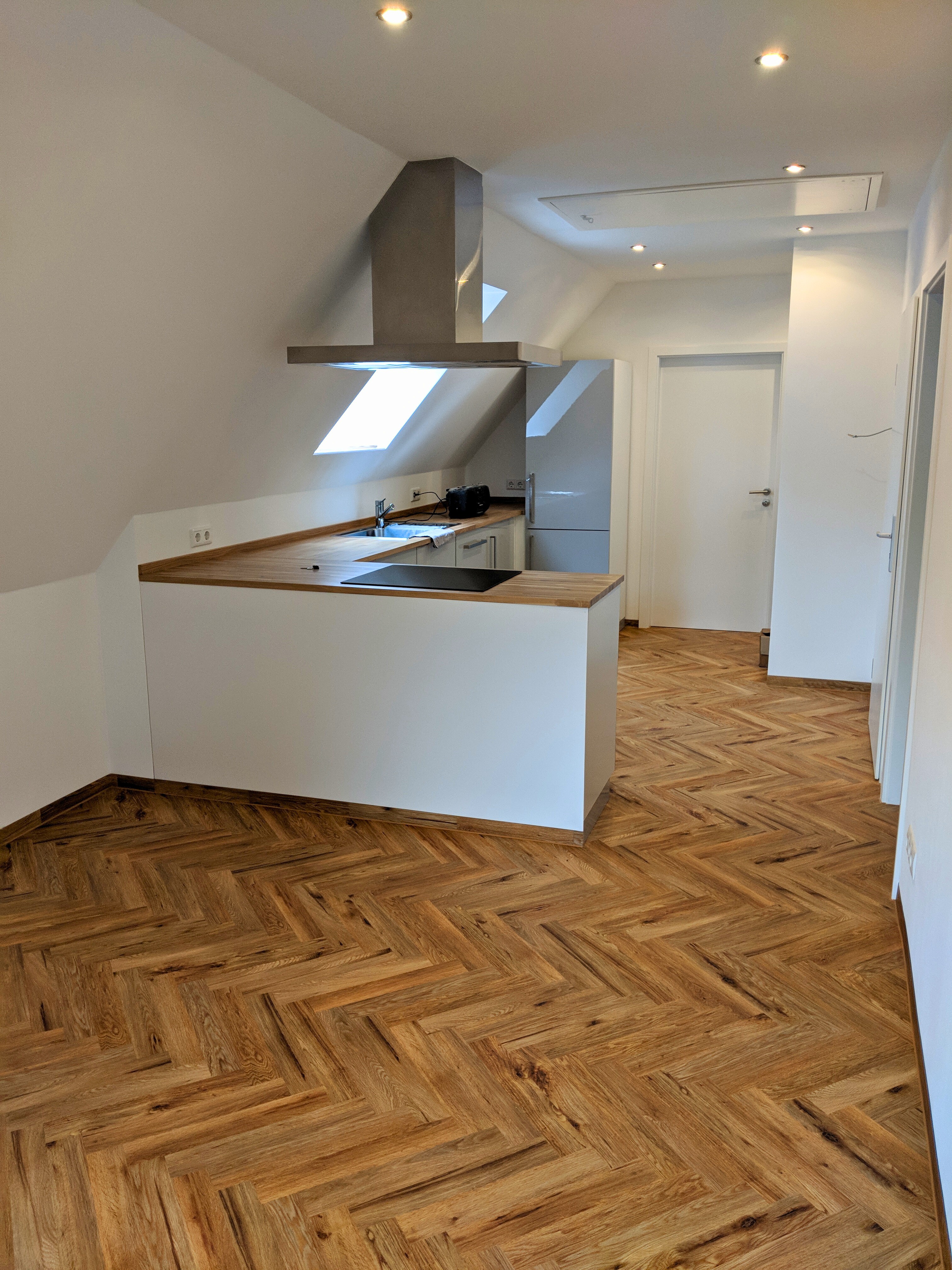 Fertiggestellte Dachgeschosswohnung mit offener Küche und hochwertigem Fischgrätparkett