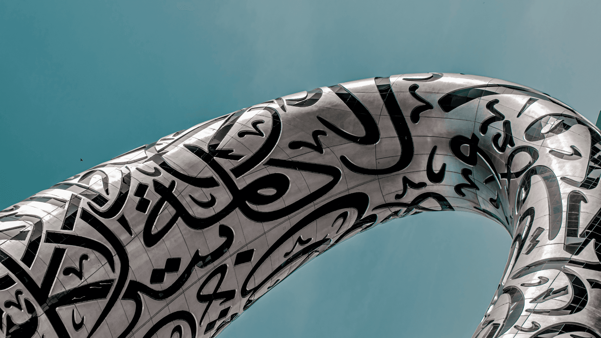 Architectural close-up of the Museum of the Future in Dubai with Arabic calligraphy under a blue sky | Lunasole Hospitality
