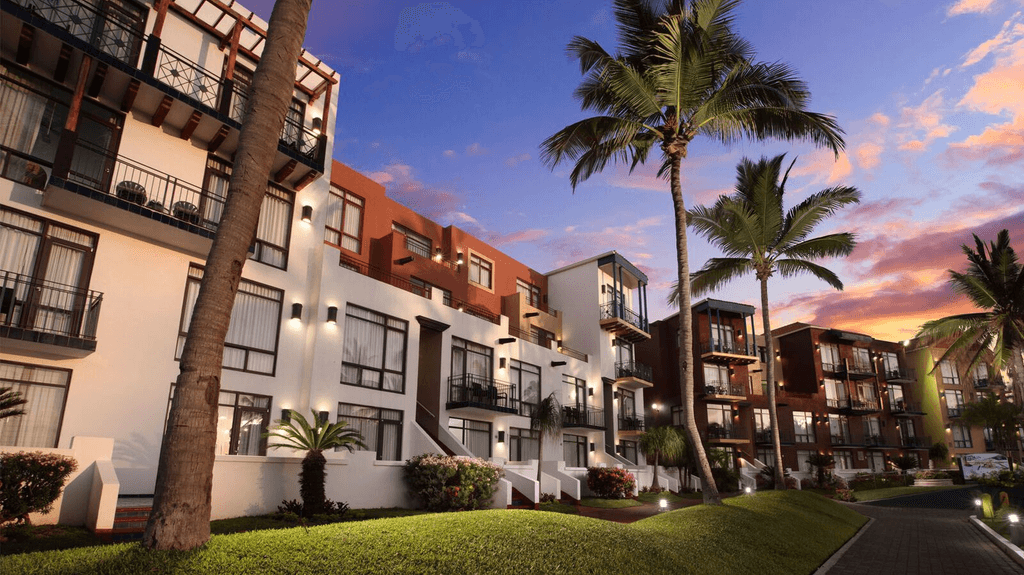 Couple standing on a balcony with binoculars in hand looking out over the ocean