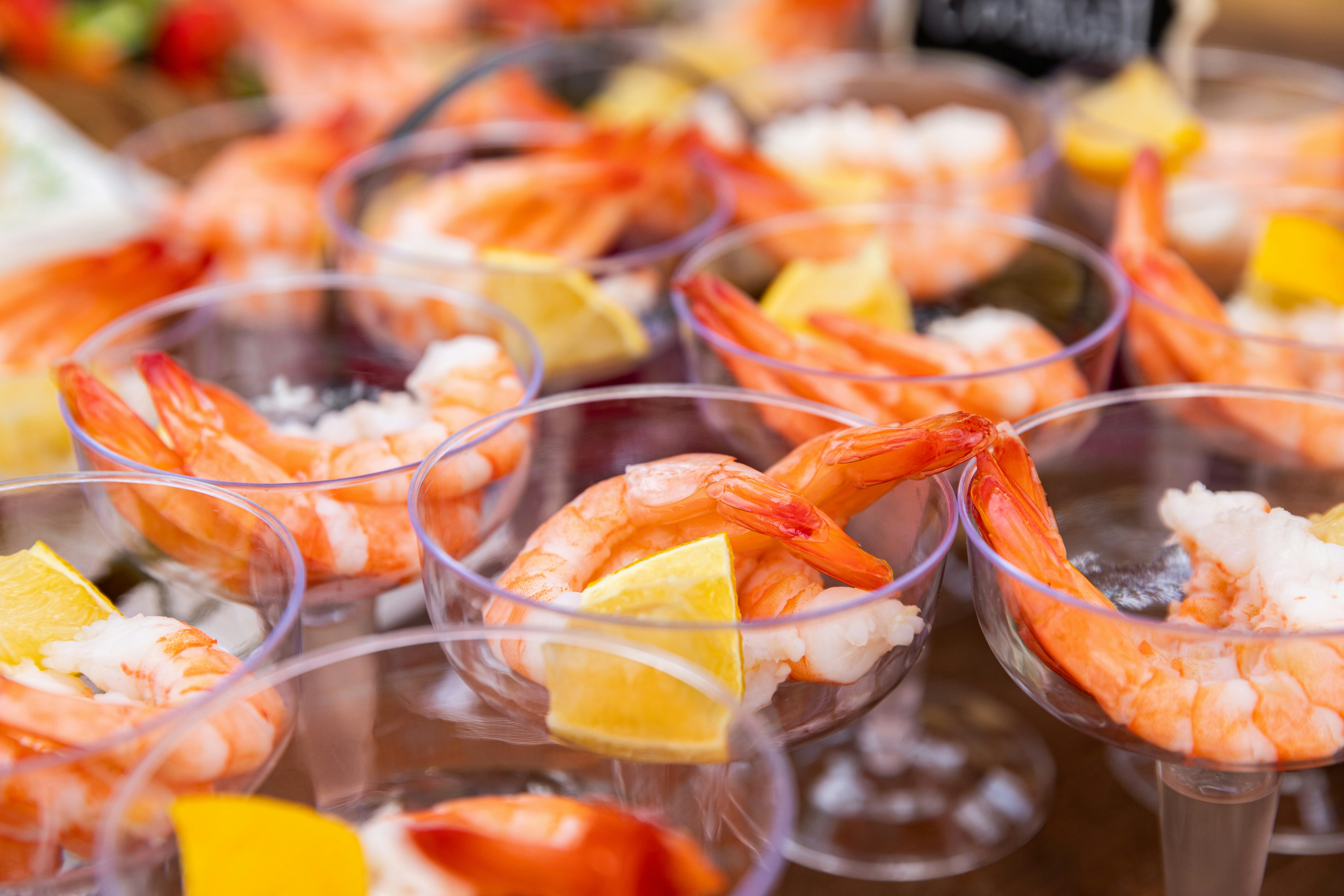 Shrimp cocktail shooters with lemon slices.