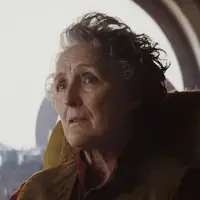 Fiona Shaw as Maarva Andor sitting in a chair in front of a window