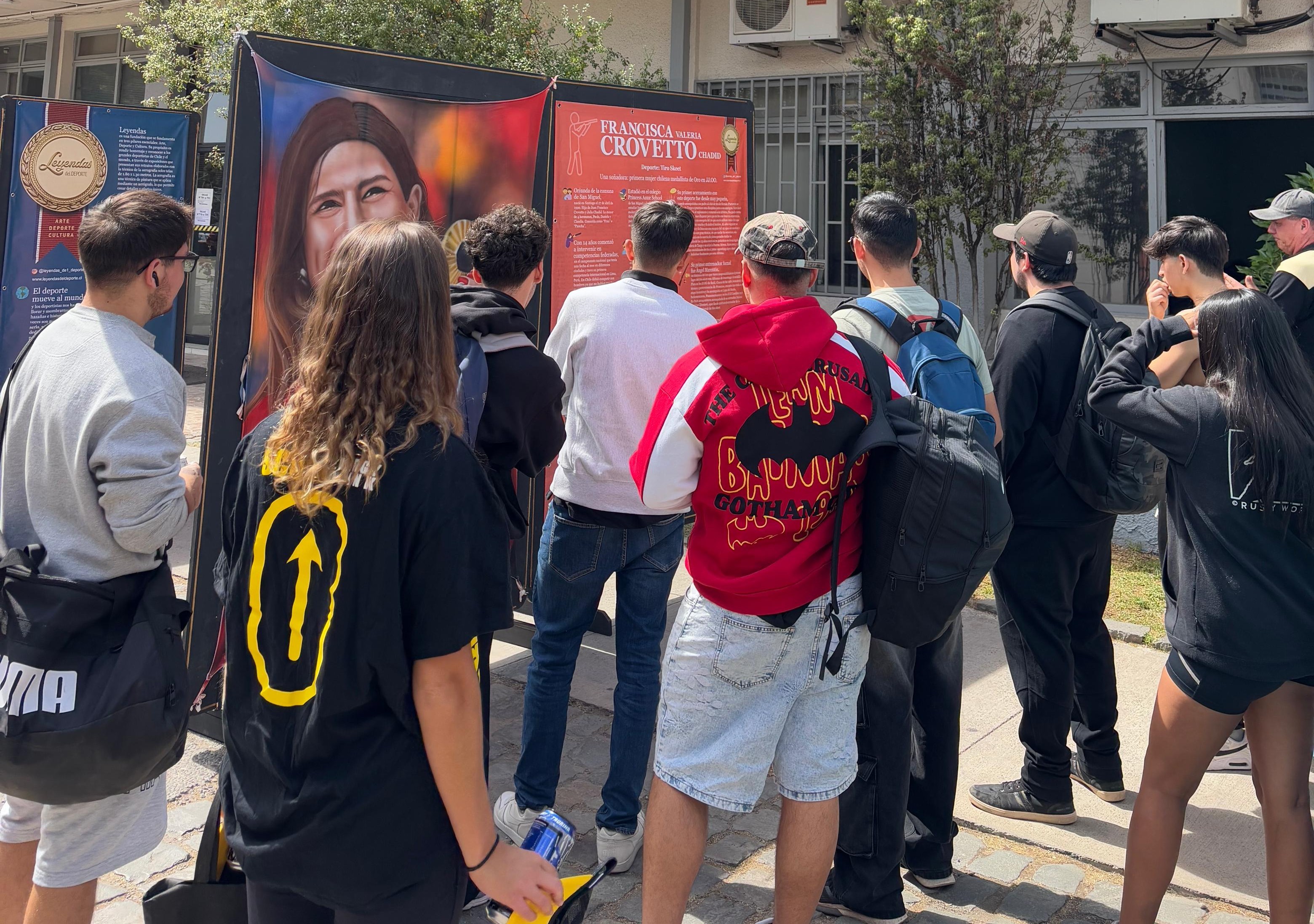 Visitantes en la exposición Leyendas del Deporte admirando la pintura de Francisca Crovetto, velerista chilena de windsurf.