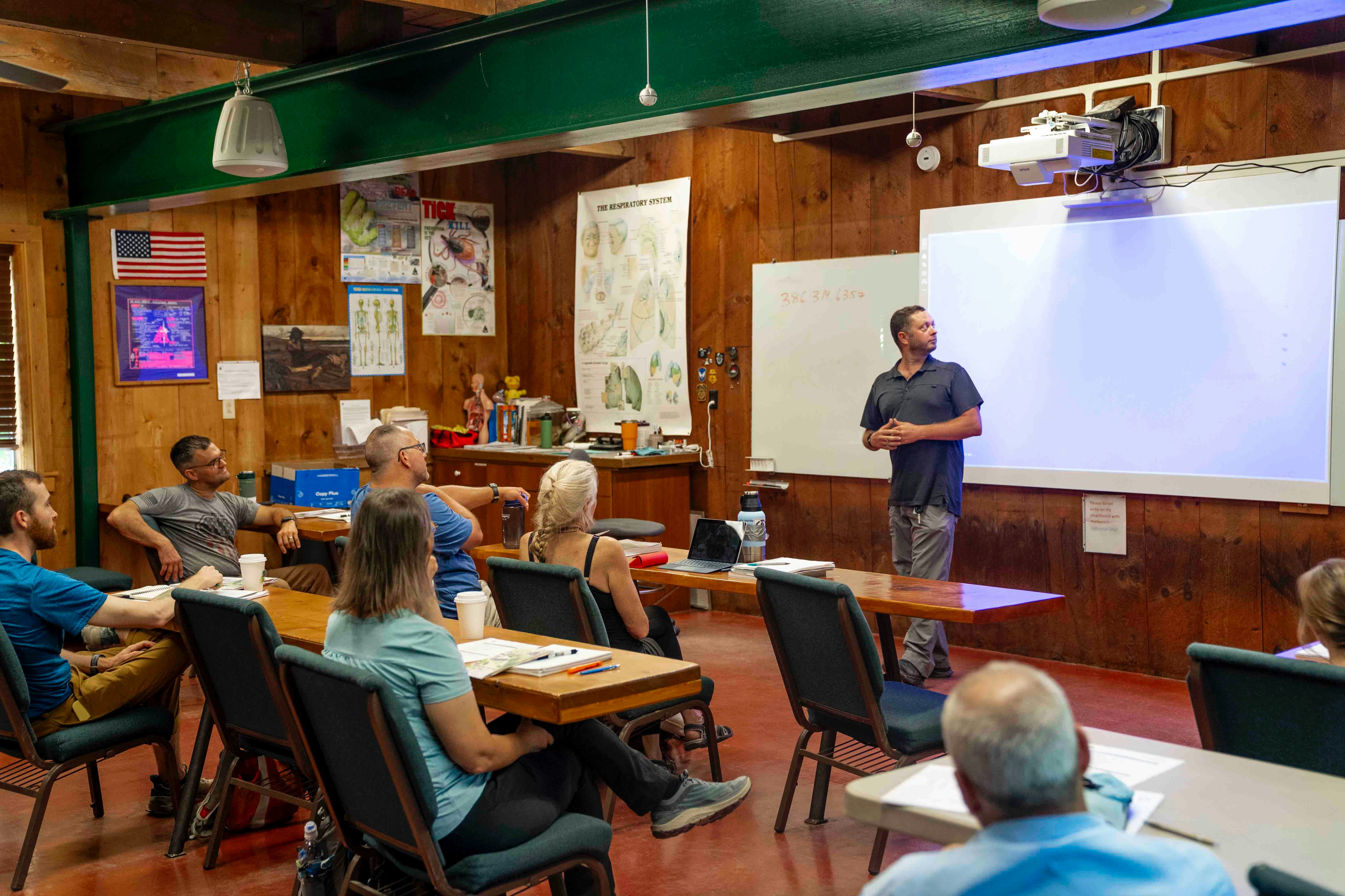 Man presents to audience in a classroom setting