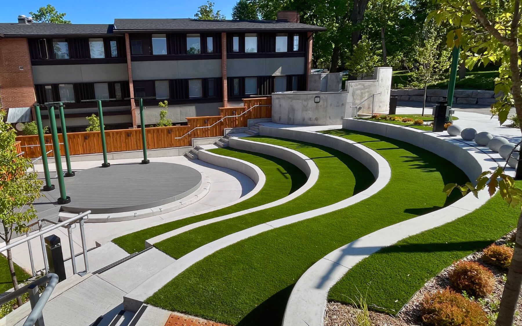 Commercial office buildings surrounding a winding amphitheater with premium AGL artificial turf.