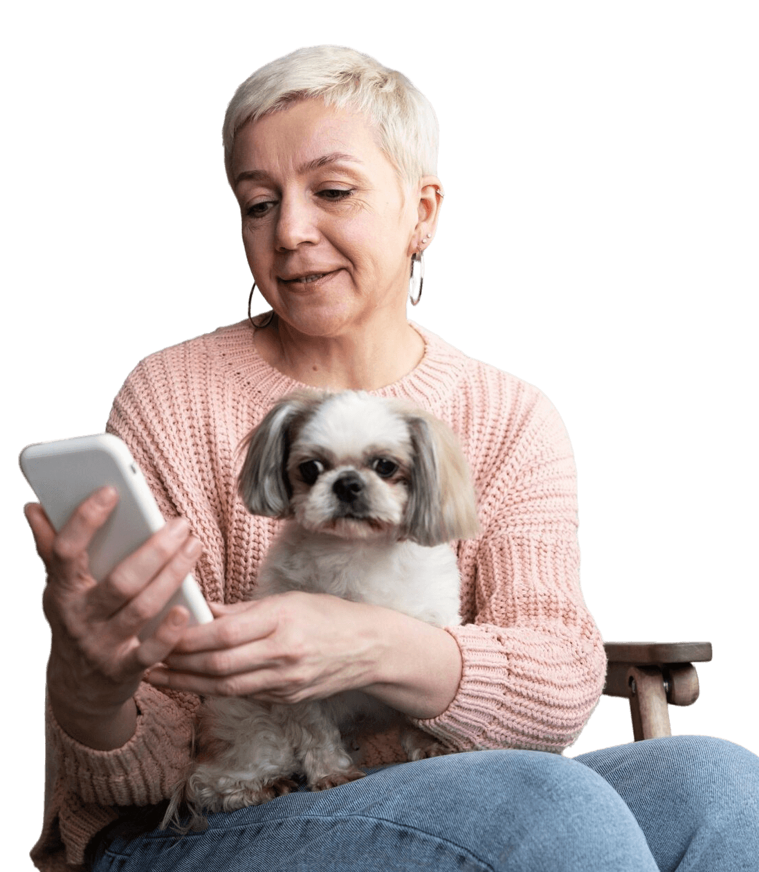 Femme âgée assise avec son chien sur les genoux tenant son portable