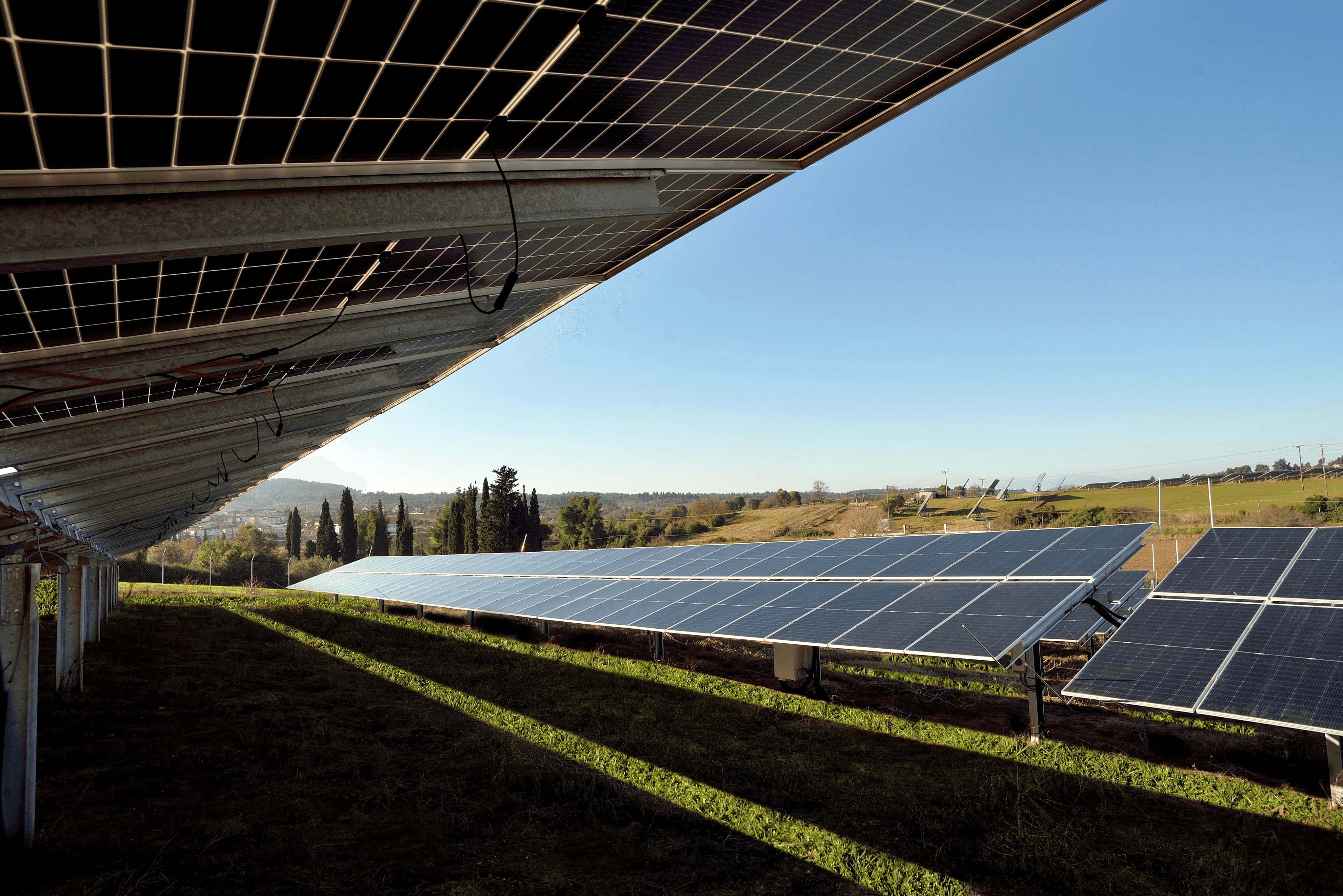 Aerial view of ground-mounted photovoltaic solar park installed across agricultural landscape