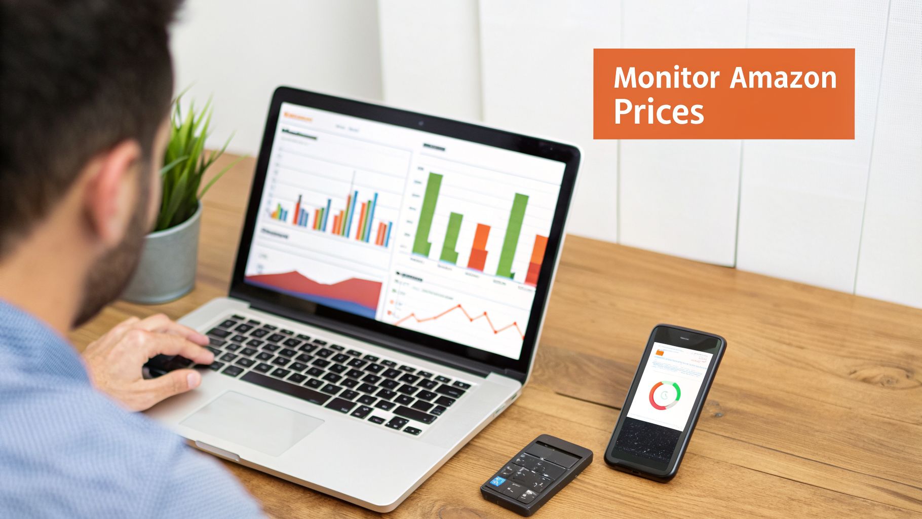 A person monitors Amazon prices on a laptop showing data charts, with a smartphone displaying a graph.