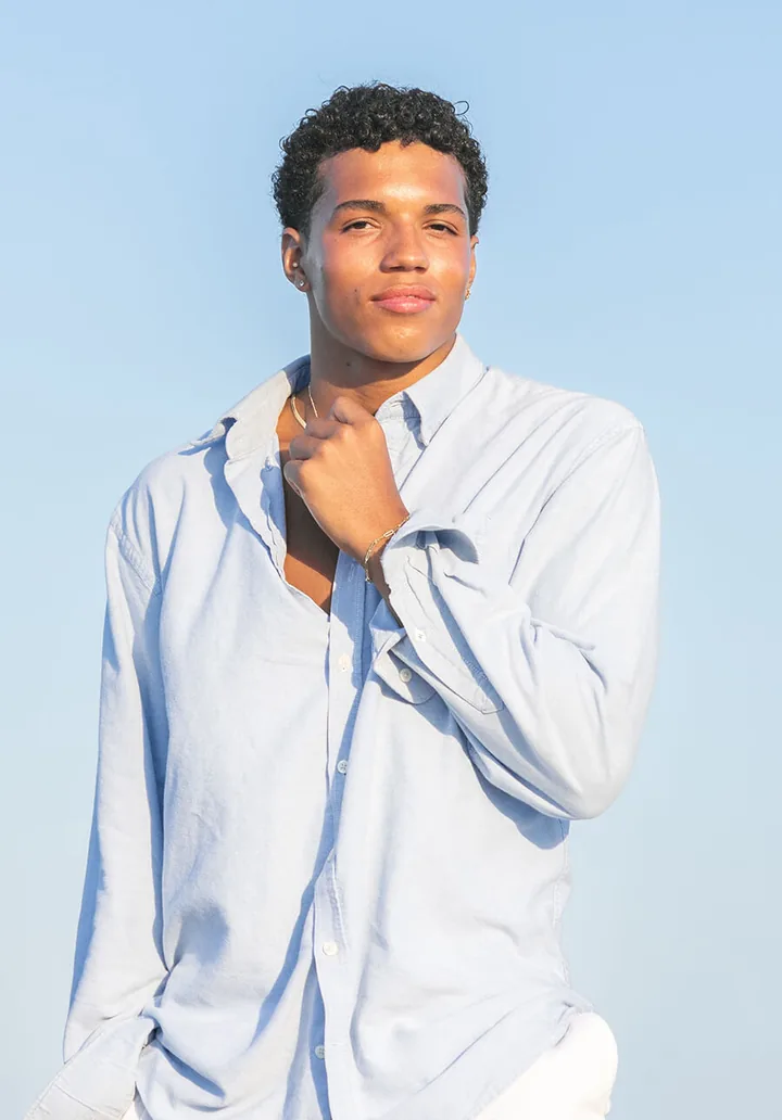 Senior portrait of a young man in a light blue shirt, by Sioux Falls, SD senior photographer Kelsey Lynn
