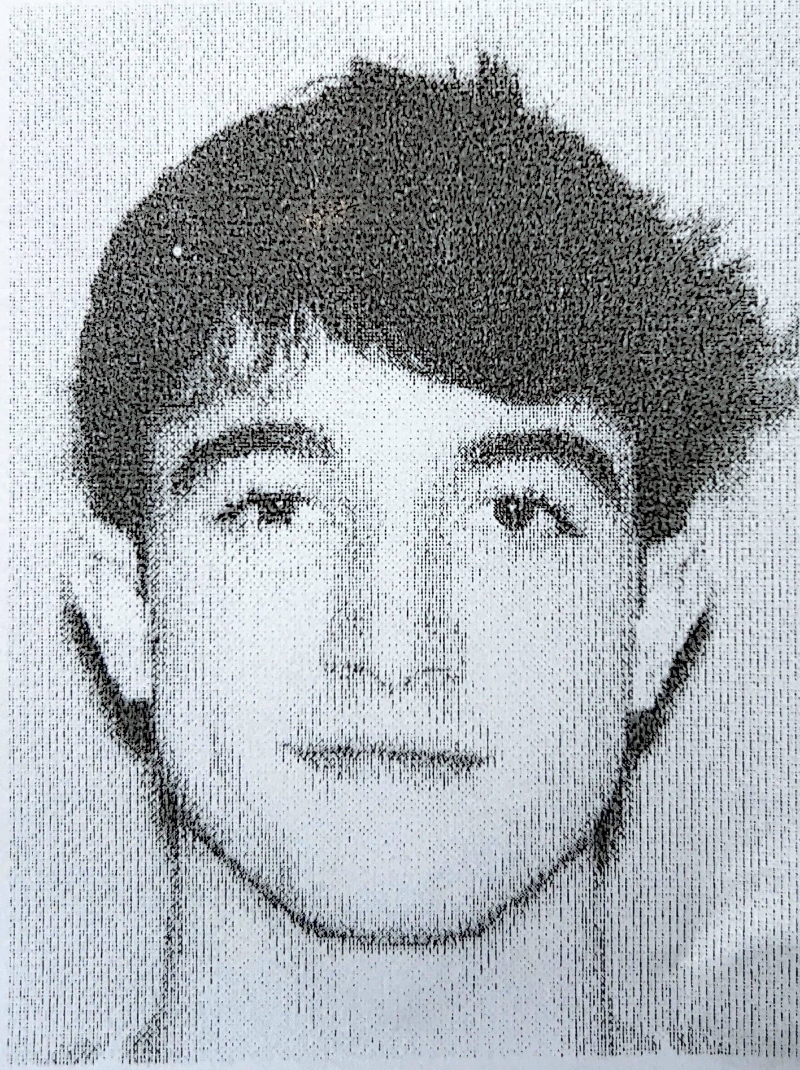 A thoughtful young person with dark hair gazes to the side, captured in soft black and white lighting.