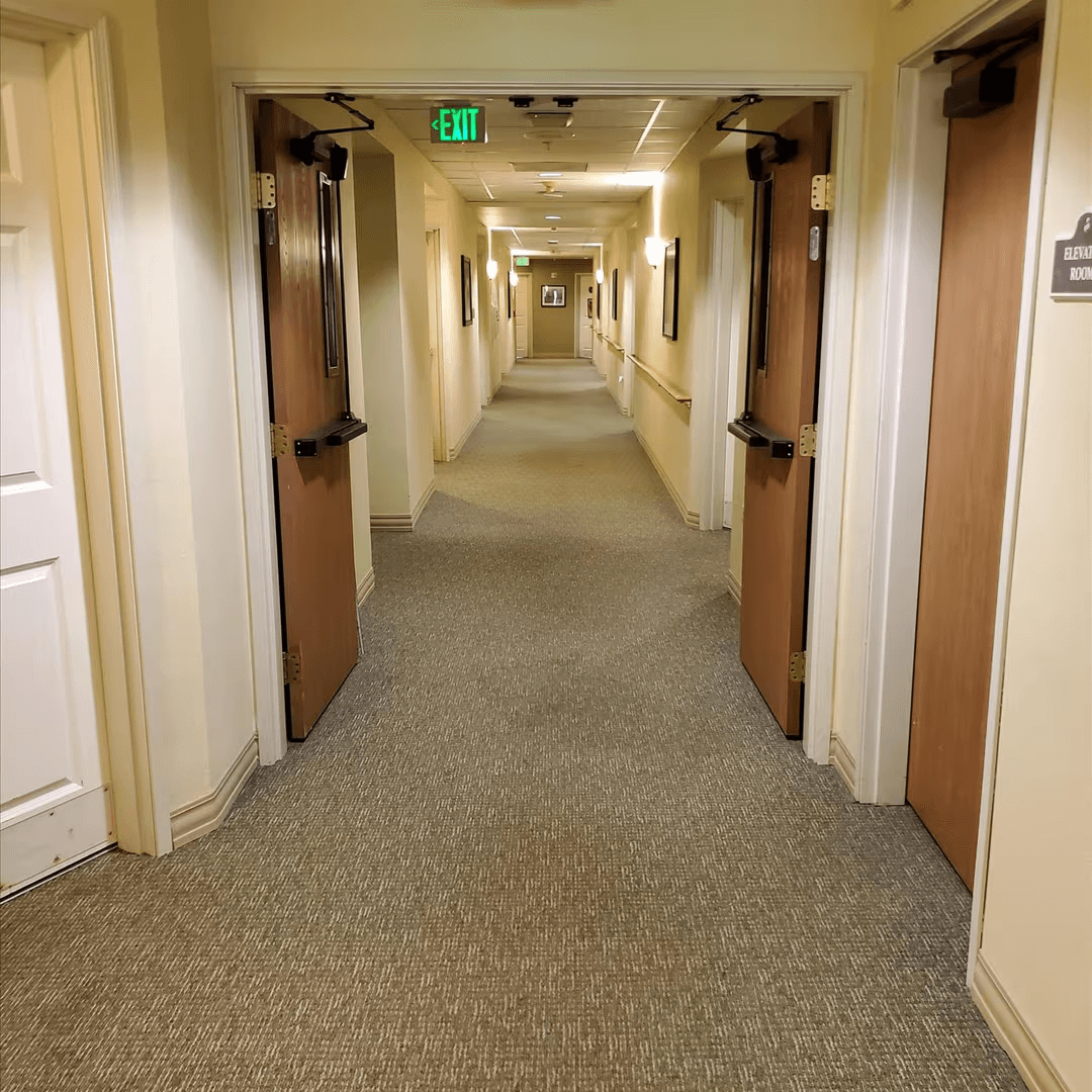 Memory care hallway within an assisted living community featuring secured resident rooms and controlled access for safety.