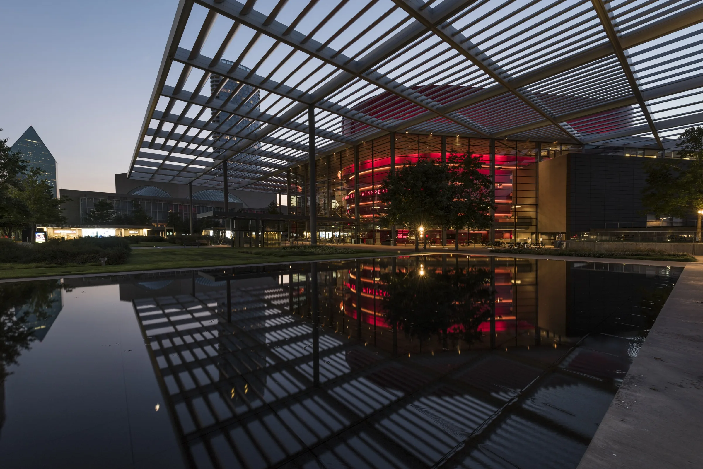 Winspear Opera House by Foster + Partners at dusk, reflected in a pool in the Dallas Arts District