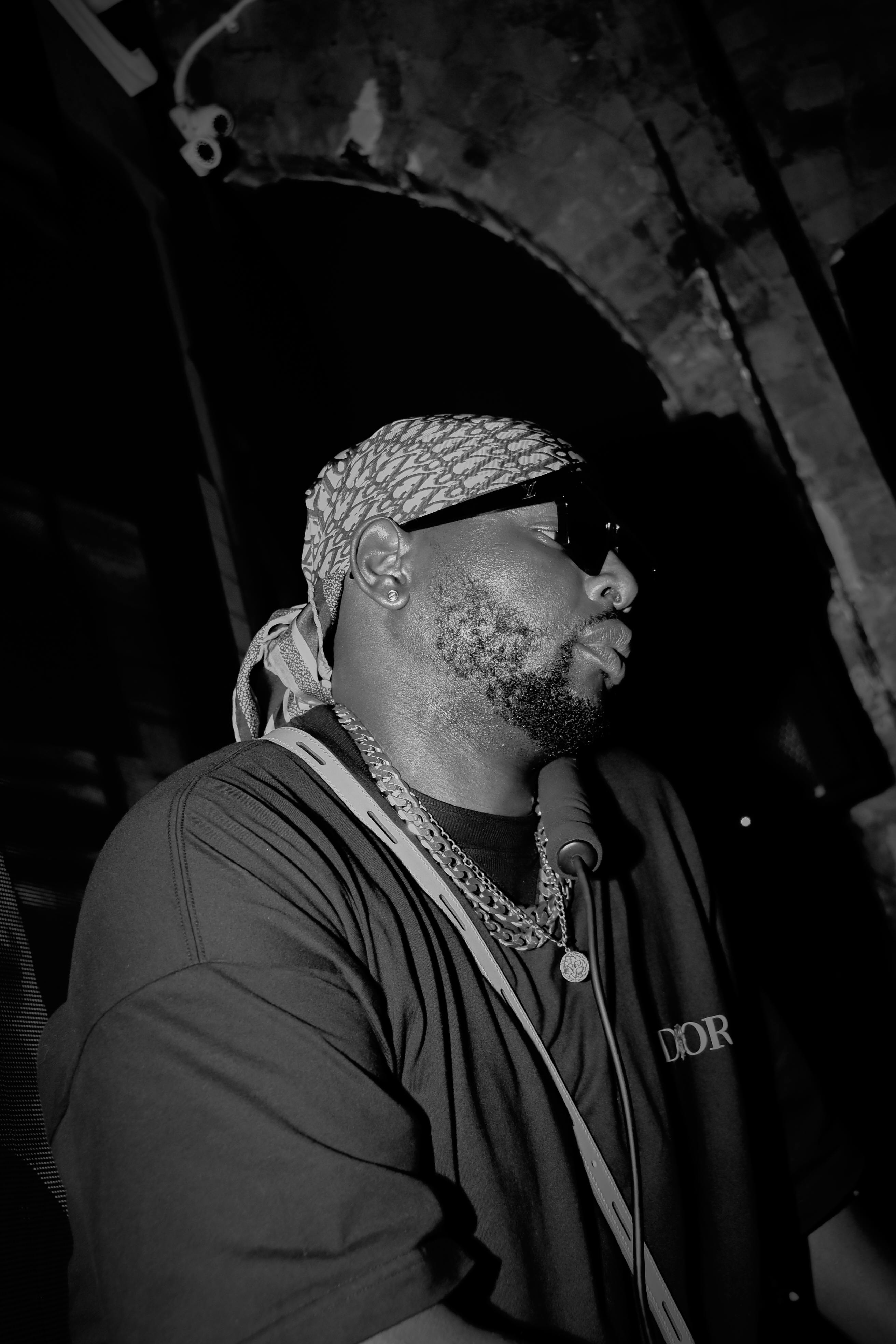 Man wearing sunglasses and headscarf in low light