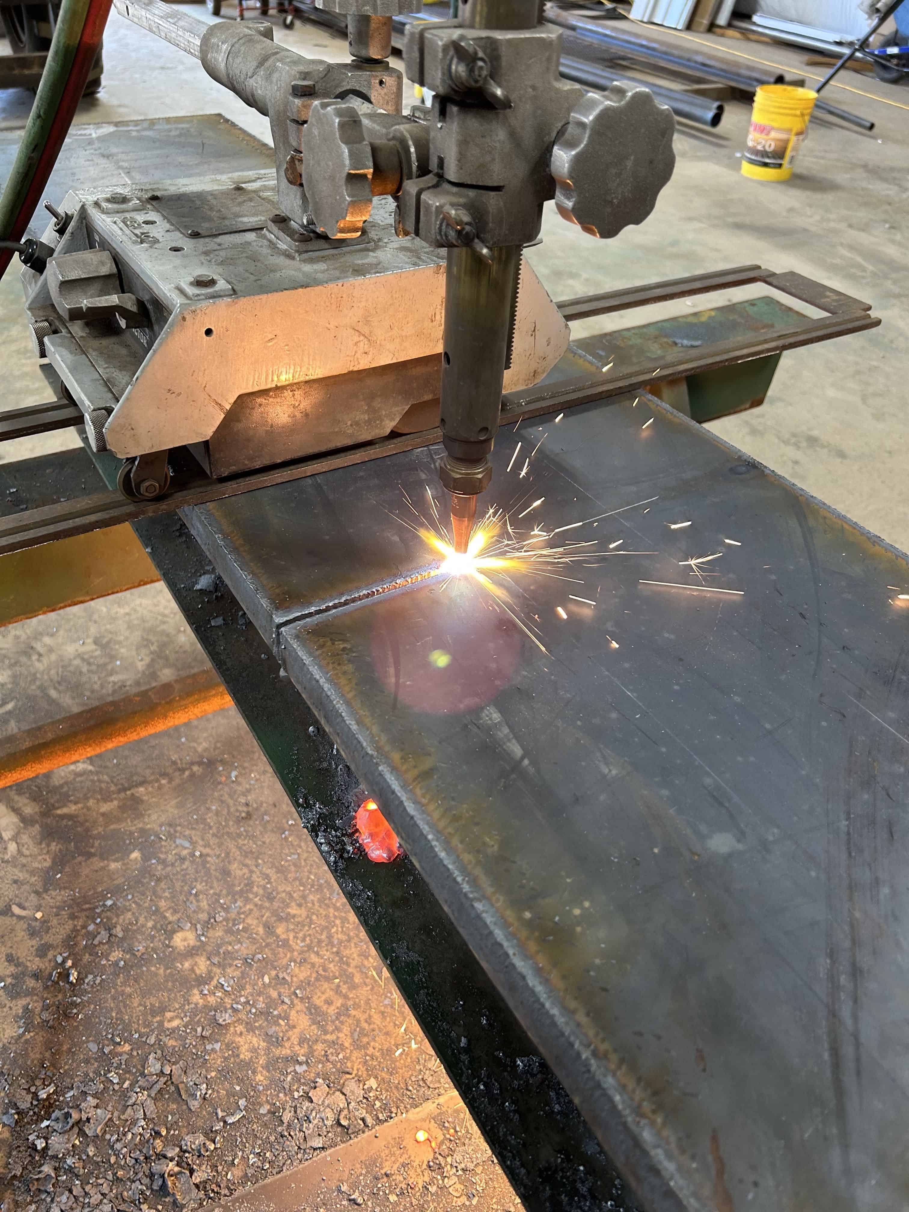  Our Victor track torch cutting through thick steel plate.  The cutting torch is creating slag and this is taking place in our fabrication shop in Henderson, Texas.