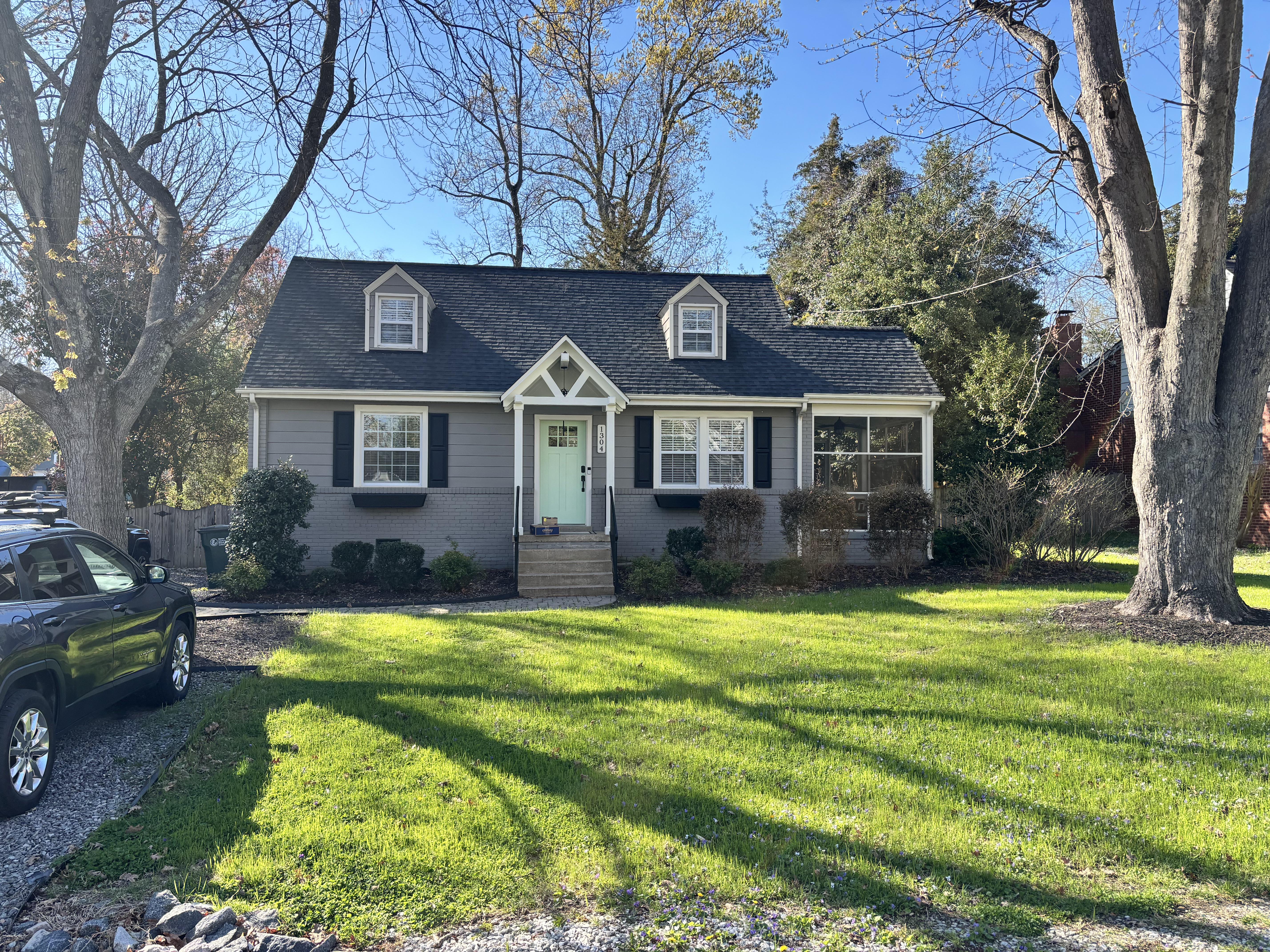 The original Cape Cod exterior with faded mint green front door