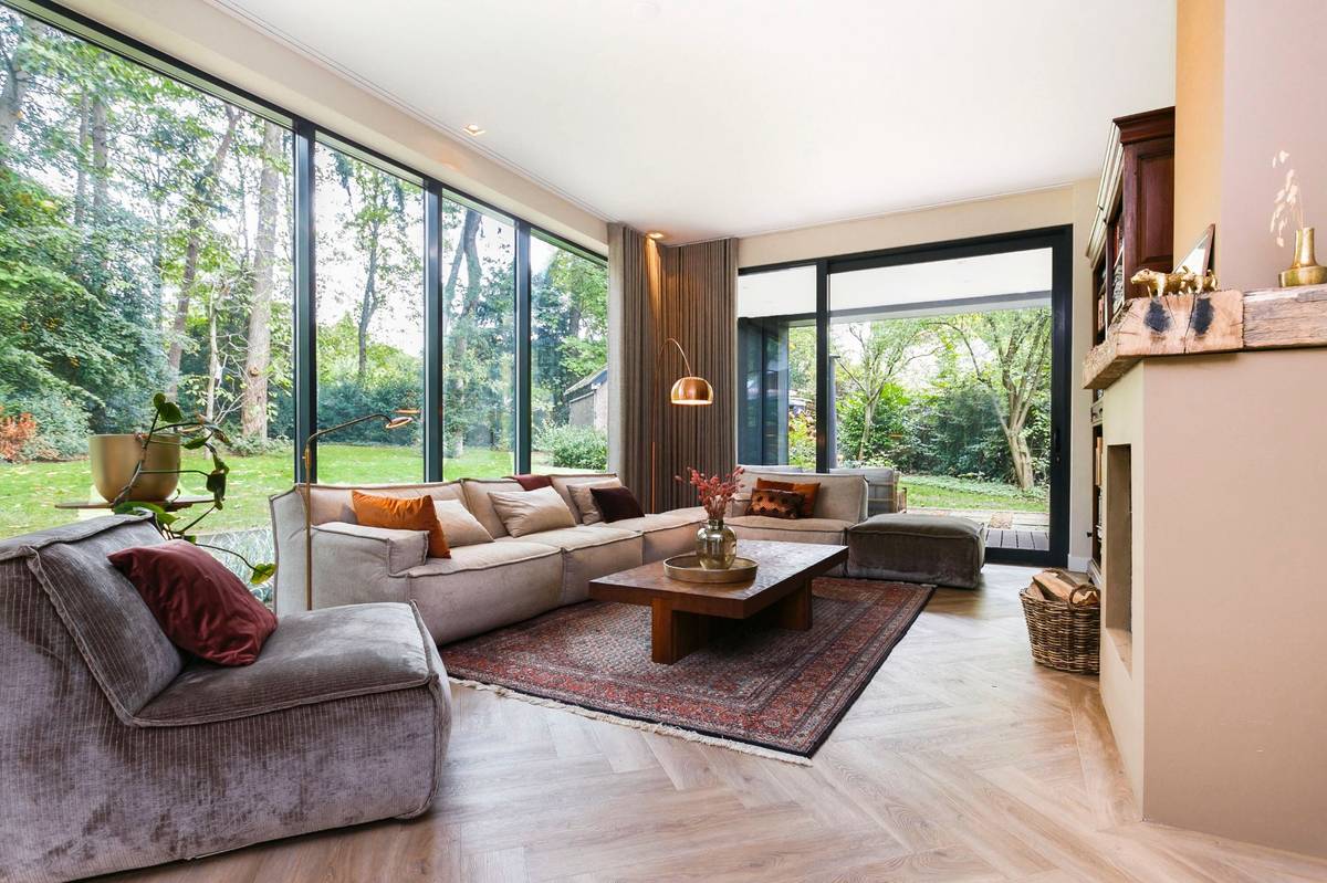 zithoek bosvilla met elementenbank en vintage vloerkleed