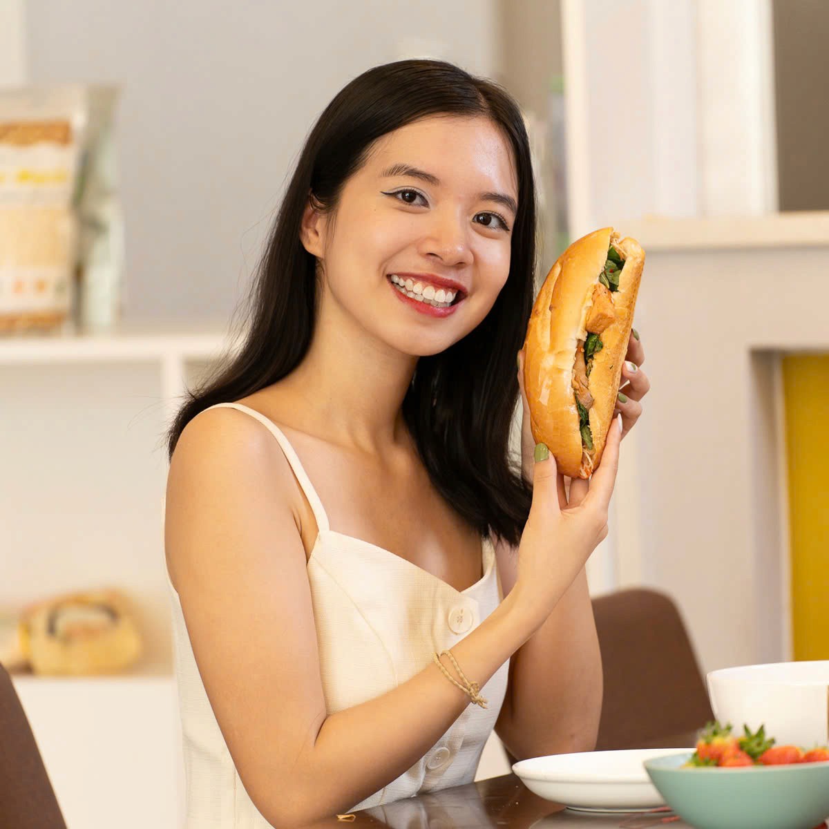 Man in apron stands in rustic kitchen, hands dusted with flour.