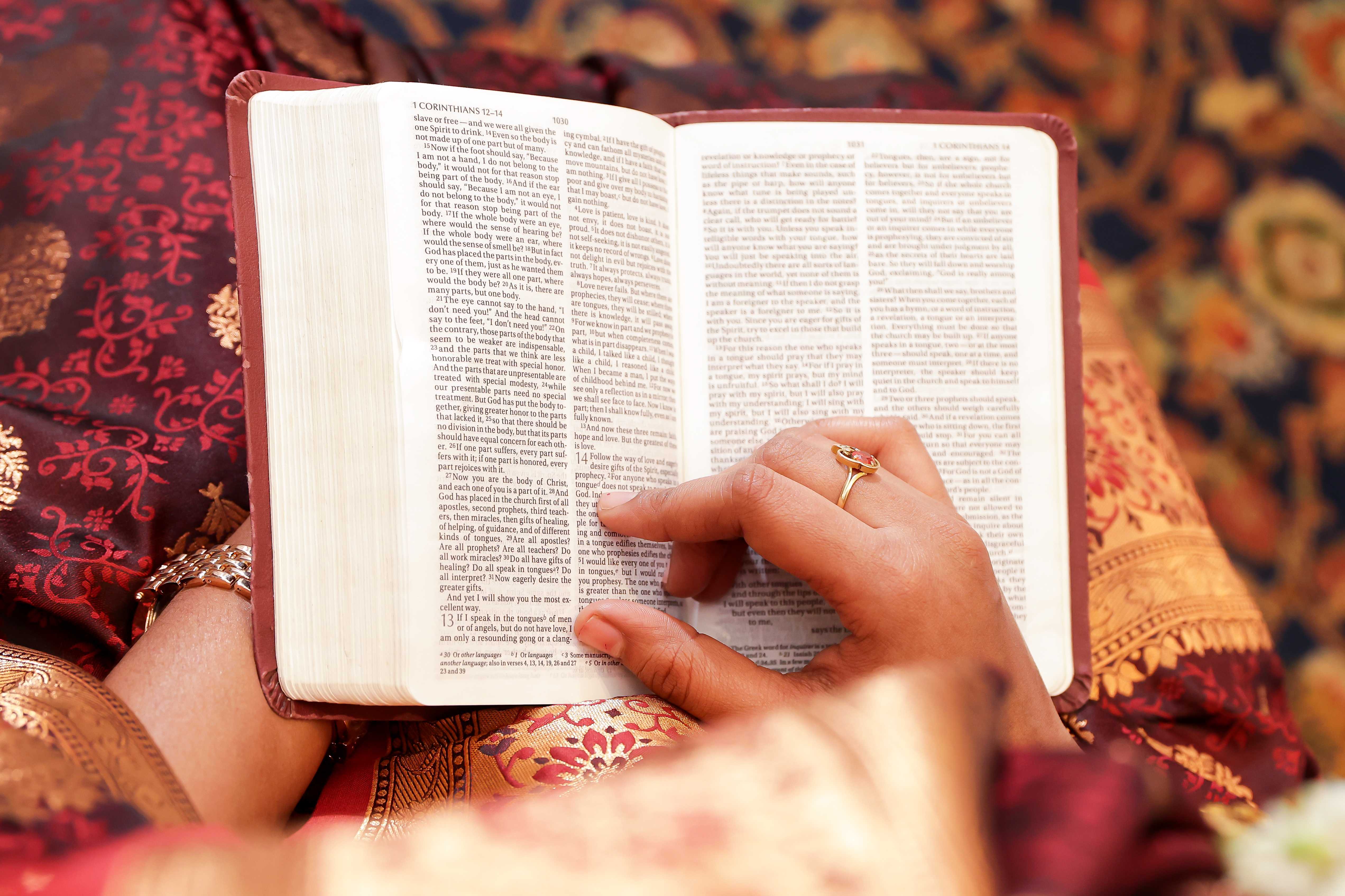 Close-up of two hands gently clasped, one wearing a sparkling engagement ring. The soft lighting and pastel nails evoke a sense of romance and intimacy.
