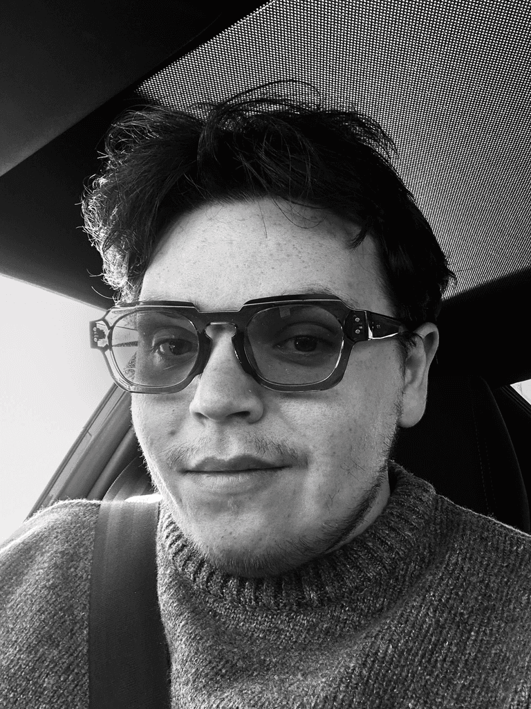 Profile portrait of a man in a white shirt against a light background