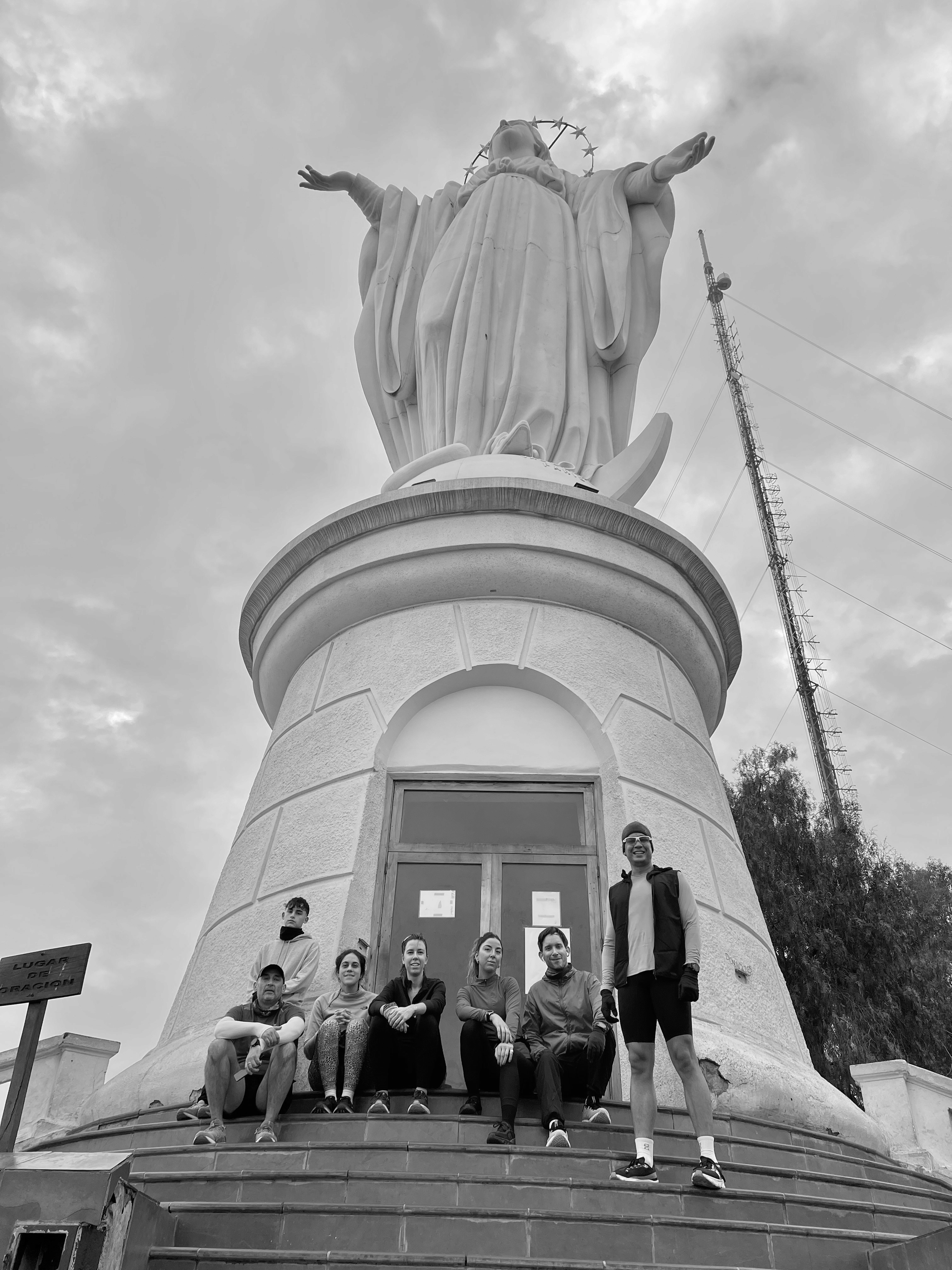 Black and white photo of two people looking at a computer screen with papers on wall