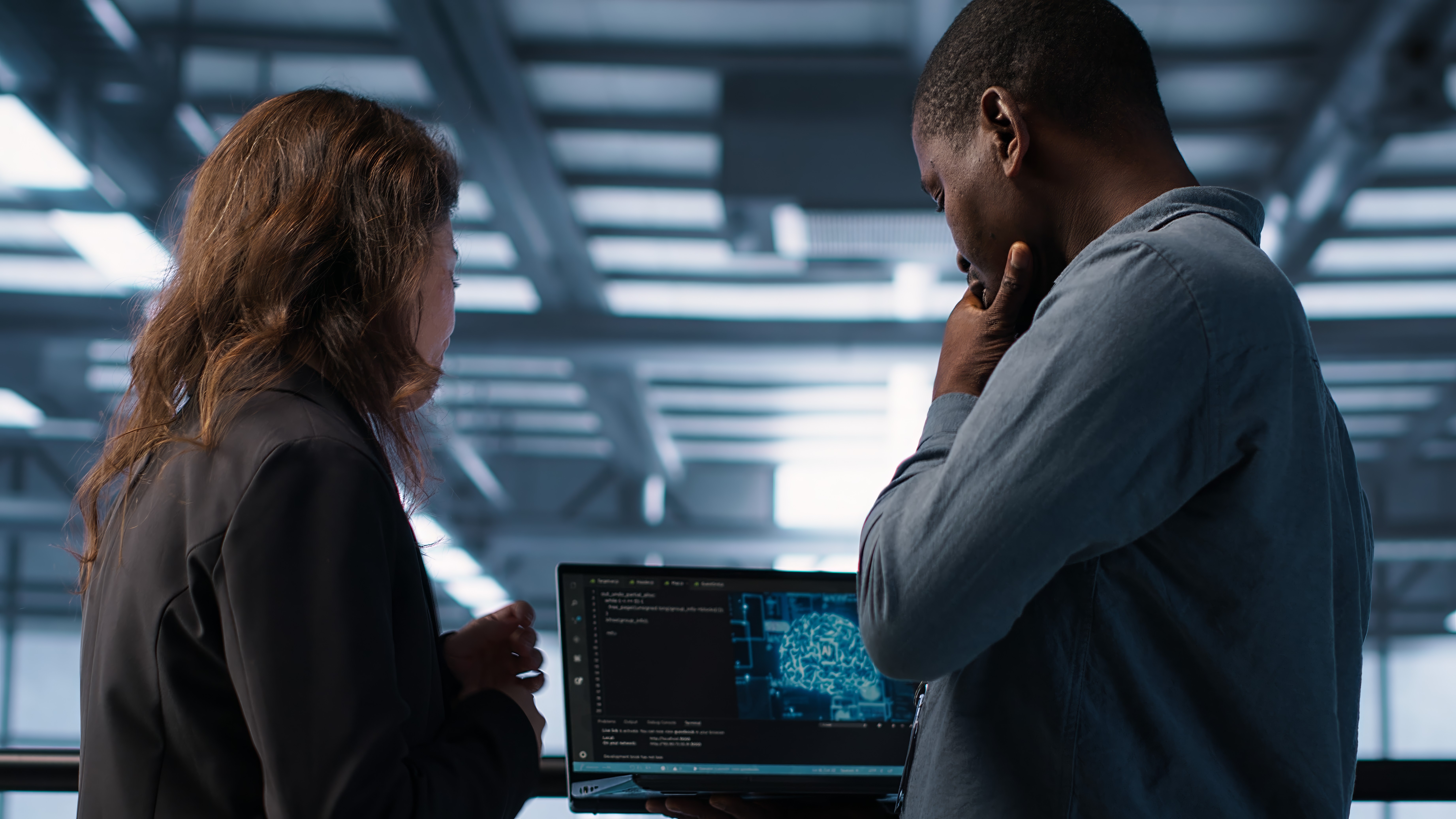 A caregiver assists an elderly woman with walking. The caregiver is smiling as the woman looks on with a smile.