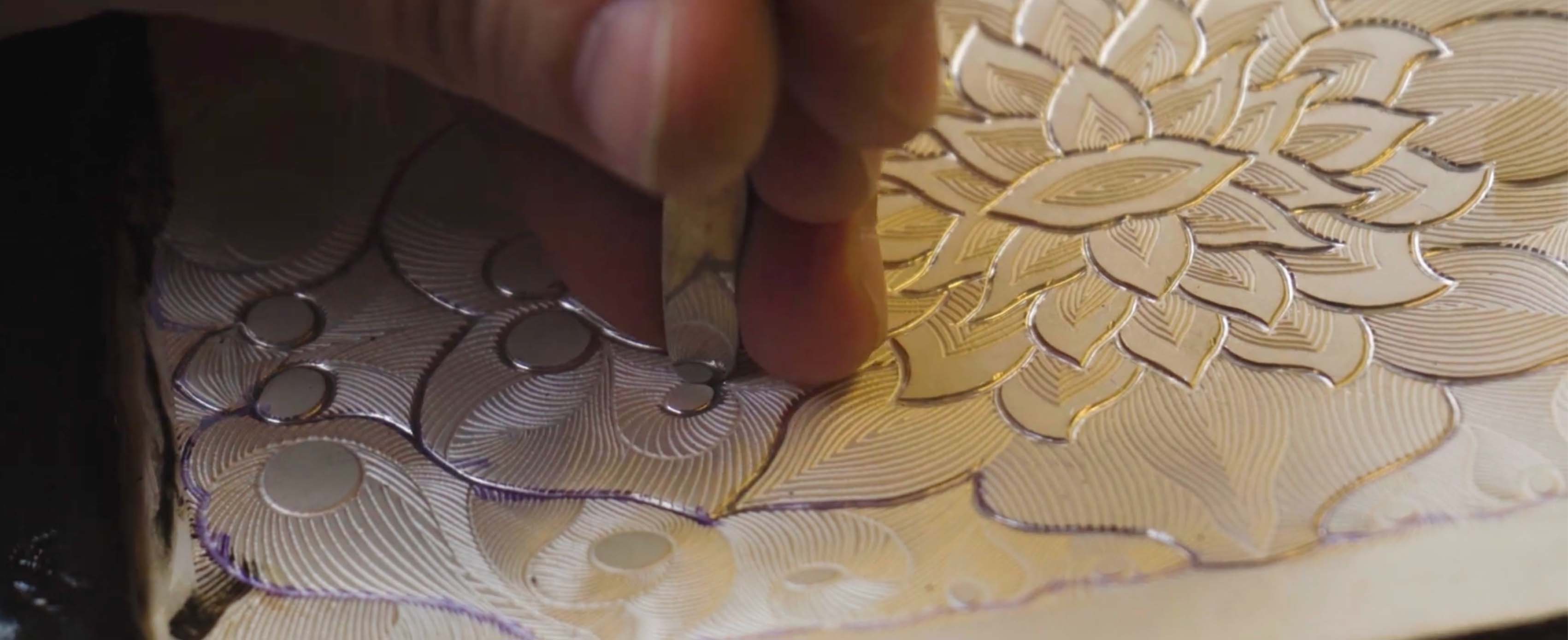 Woman in a red south asian dress standing with arms raised on a dimly lit stage surrounded by decorative metal vessels.