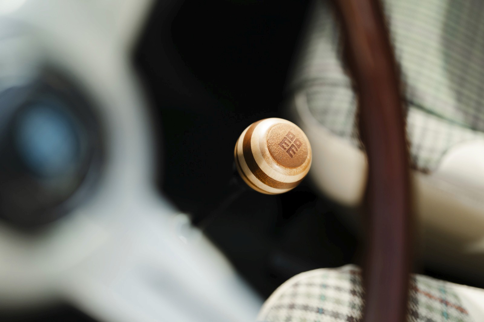 Close-up of a small metallic button or knob, slightly out of focus, with a blurred background.