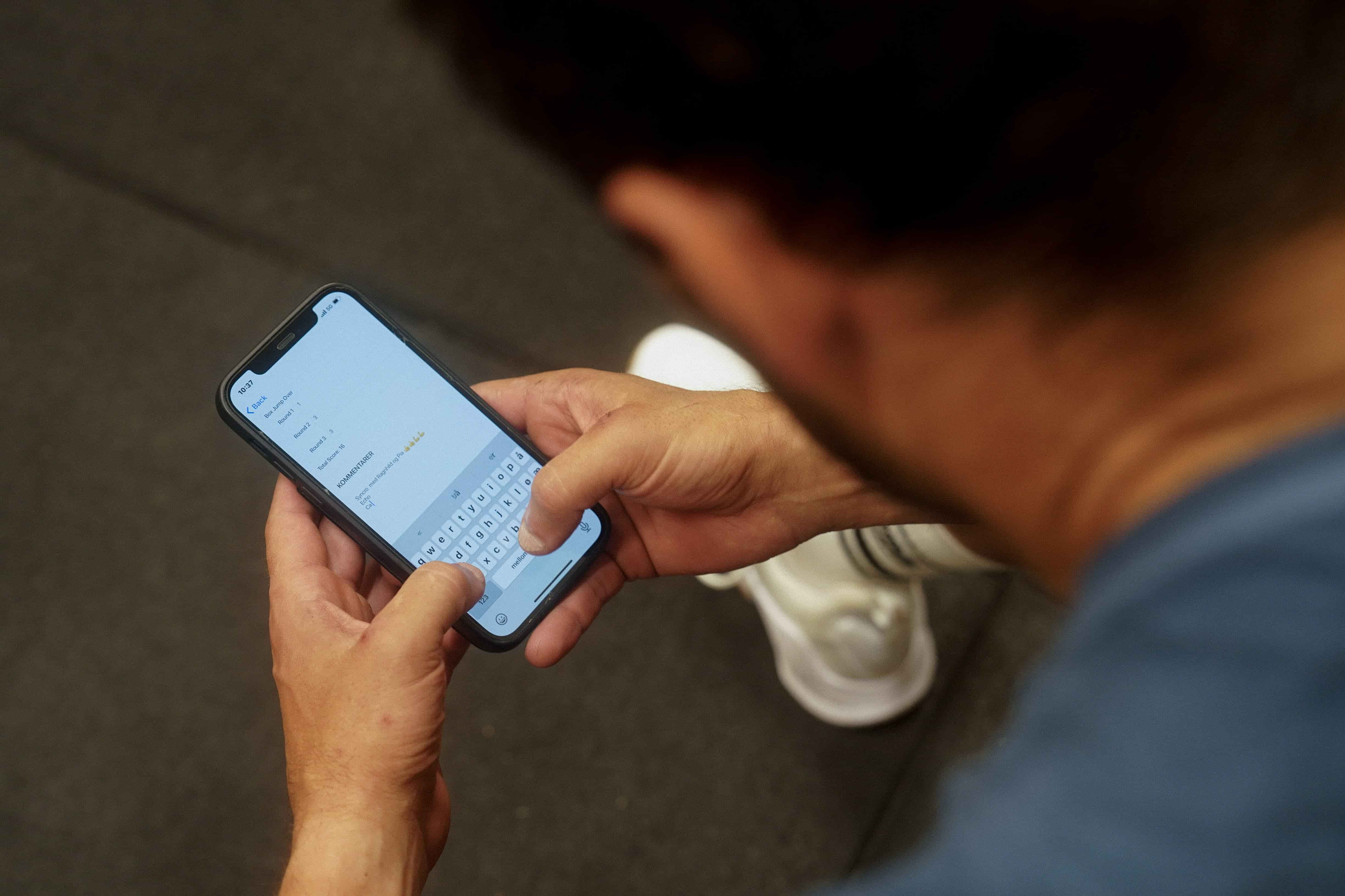 En mann logger økta si på telefonen